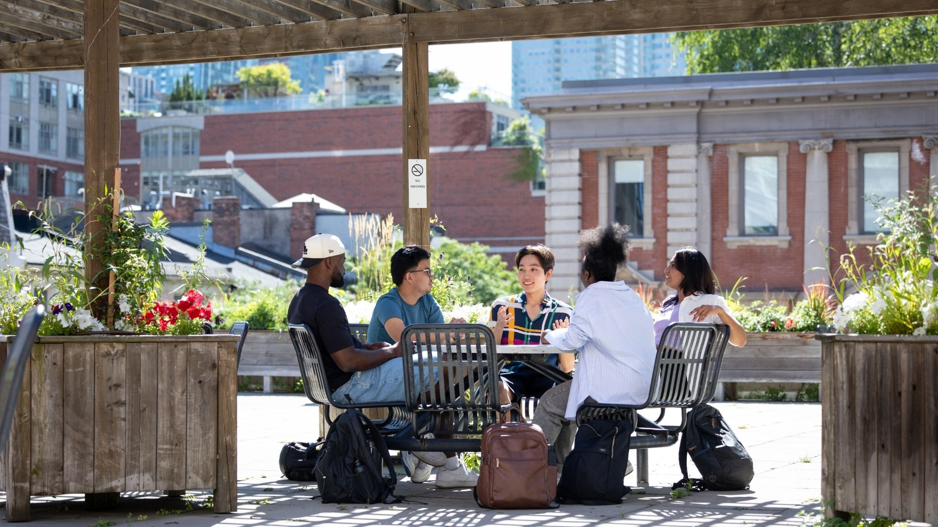 A group of students sit on the St. James patio together.