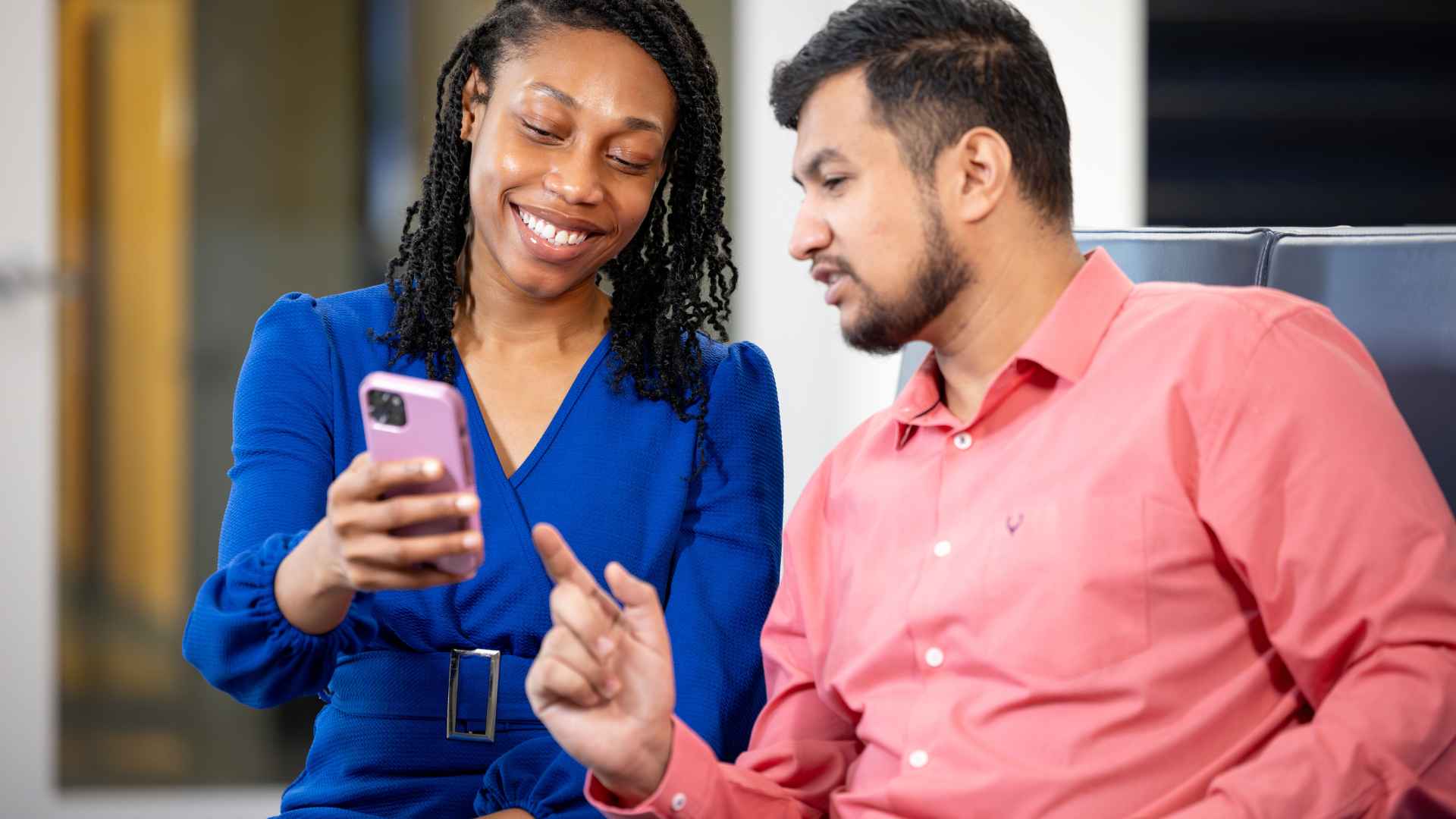 One student shows another student their phone.