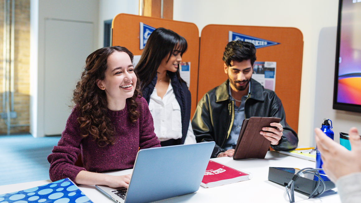 Students laughing in a Digital Media classroom