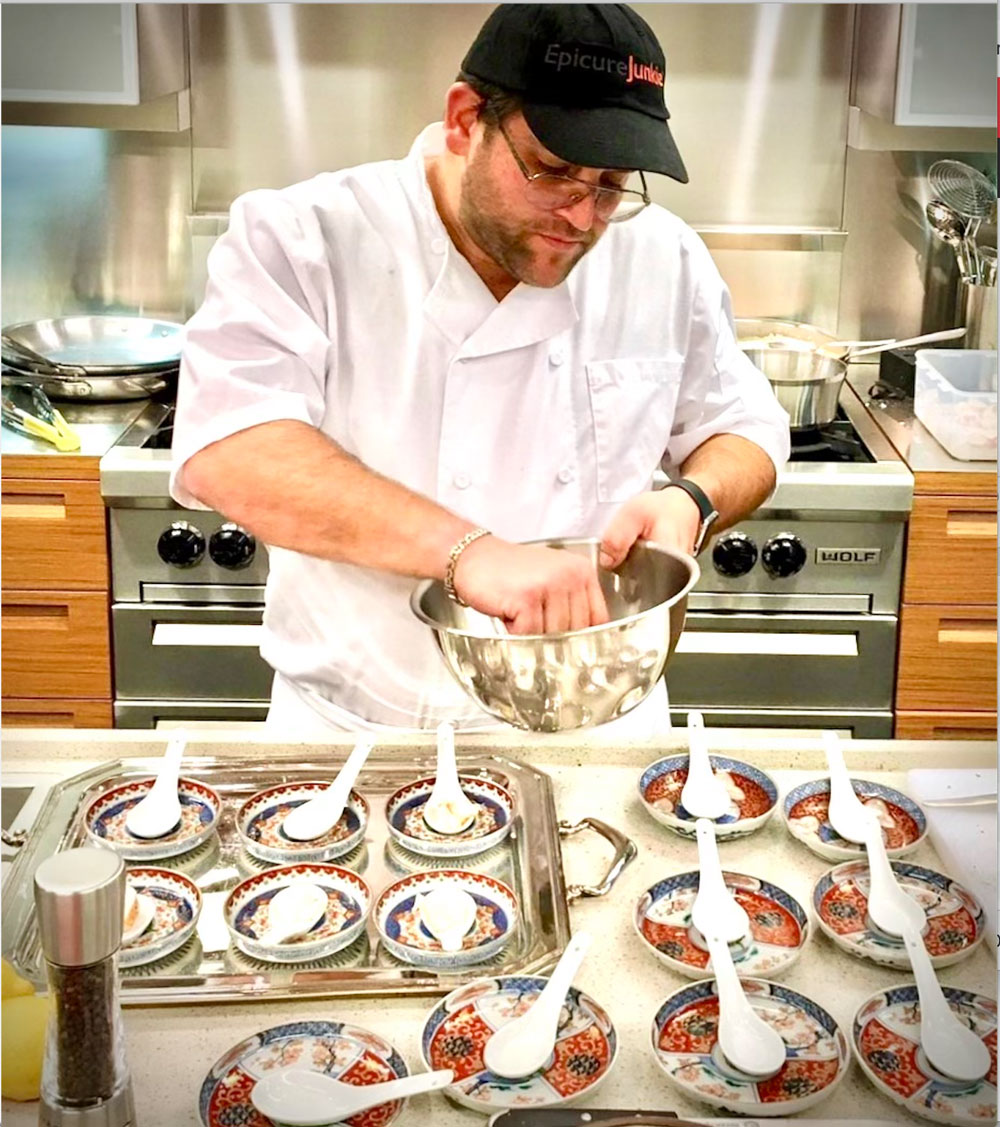Chef Michael Fingold in the kitchen plating food.