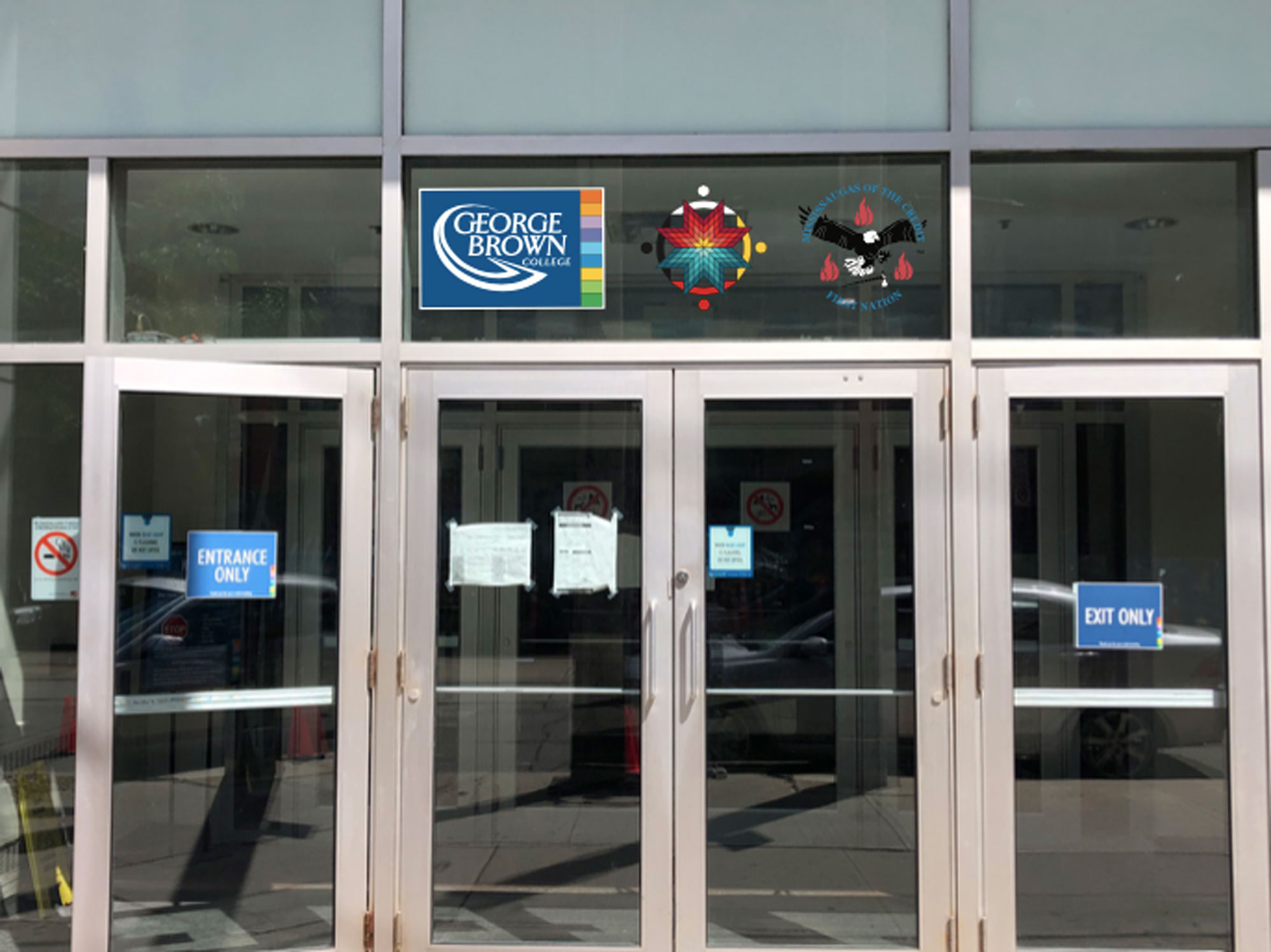 The crest of the Mississaugas of the Credit First Nation, along with the medallion of our Indigenous Initiatives team, proudly displayed next to the George Brown College logo above a campus doorway.