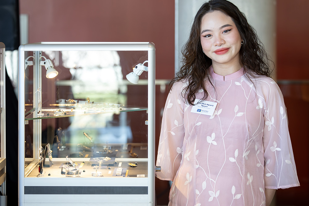 Jewellery Arts student Nina Nguyen next to a display case