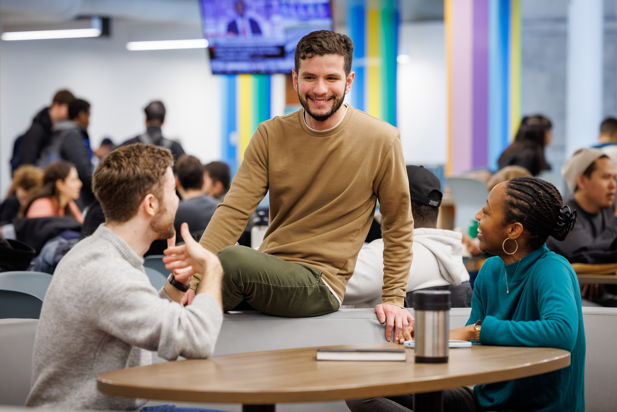 Three students chatting at a table