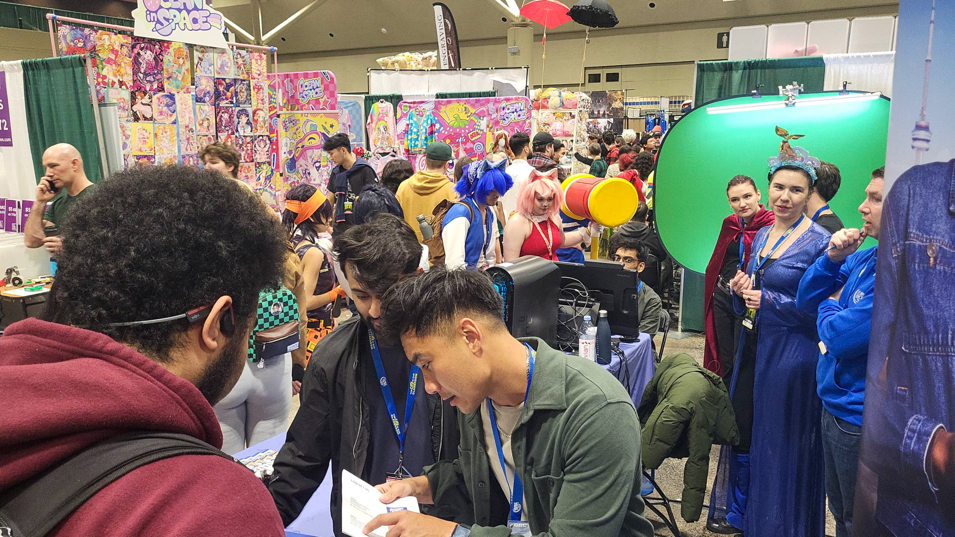 Costumed visitors take advantage of green screen photo ops at the media and performing arts booth at Toronto Comicon