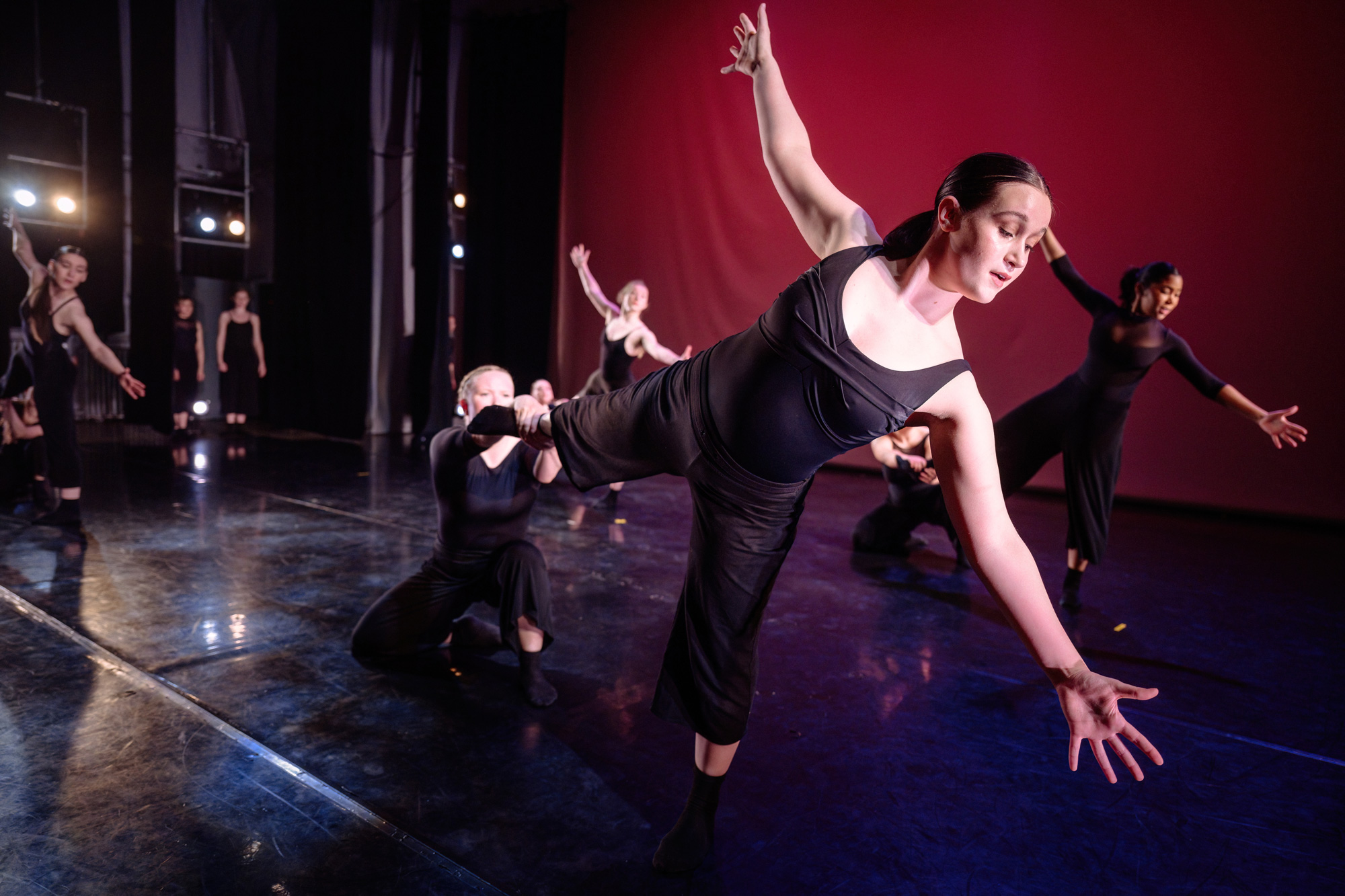 A dancer in a prodution of Unleased stands on one leg with arms outstretched