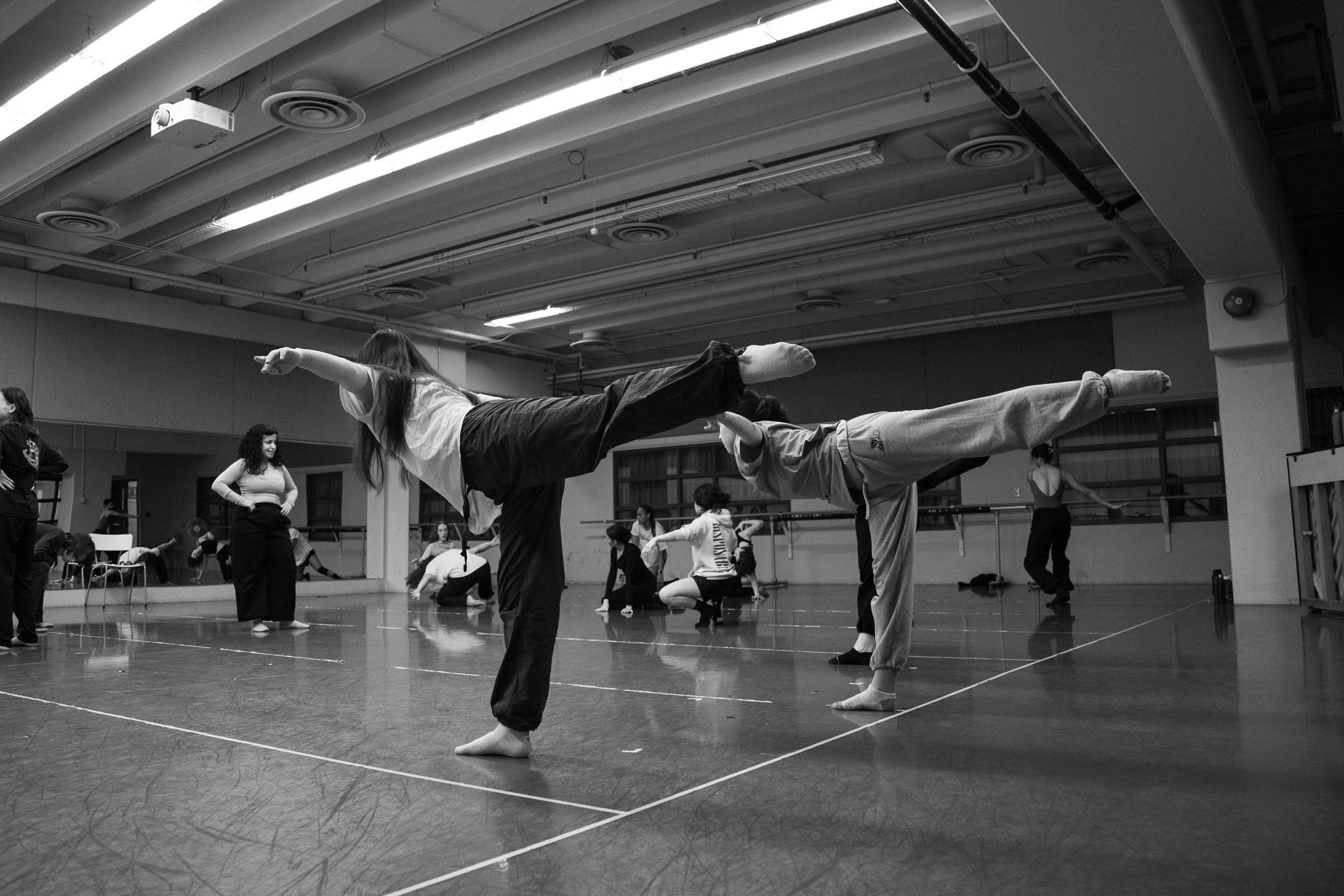 Dancers in the George Brown dance studios practice a routine on one leg with one arm outstretched