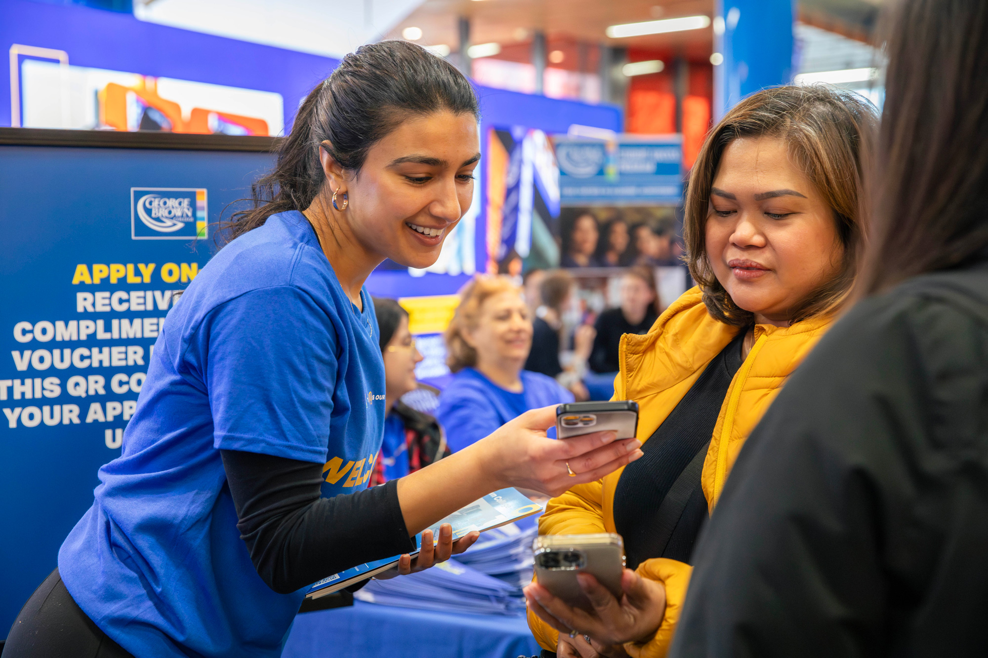 A student helps a visitor at the open house