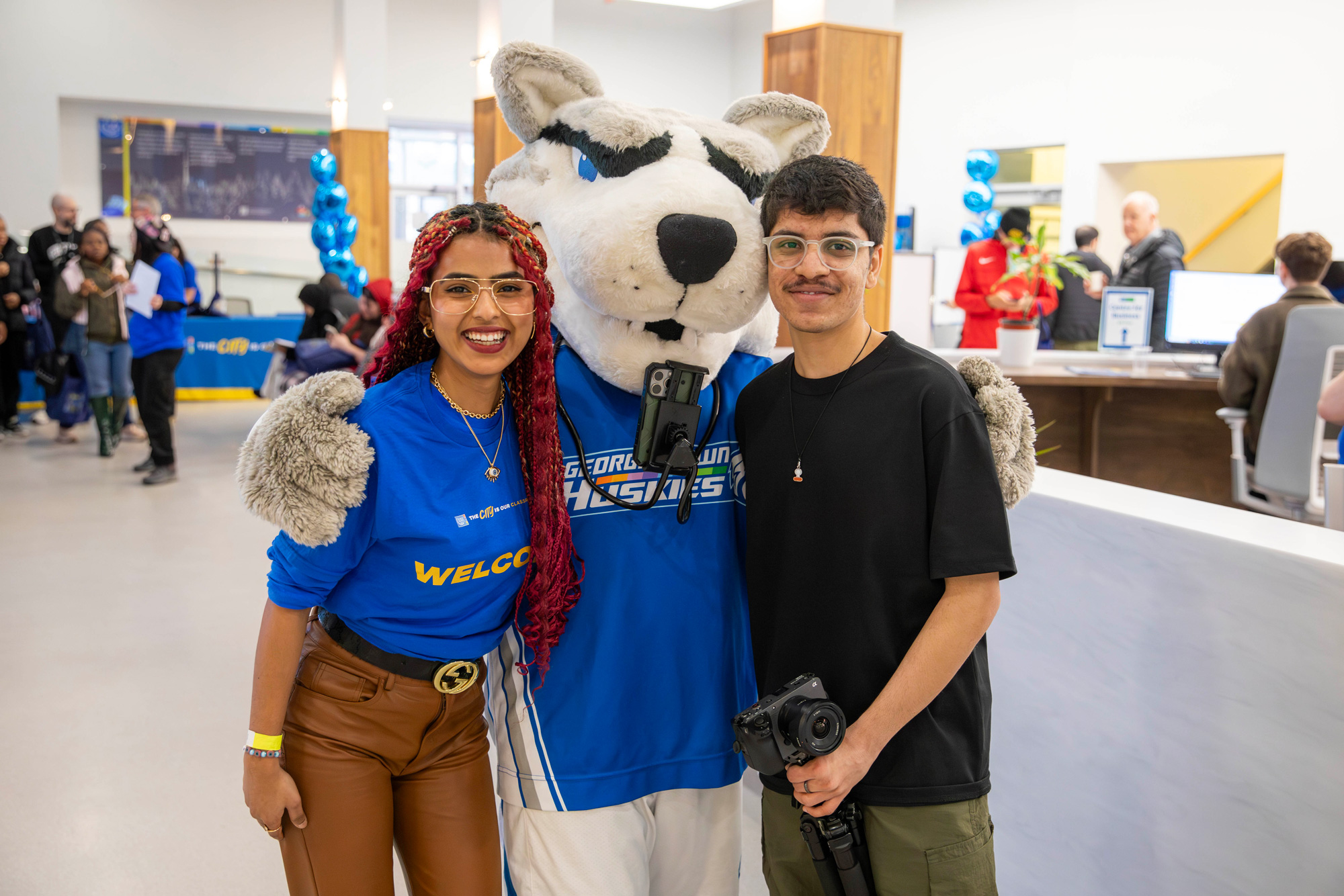 Two students pose with Helder at the open house