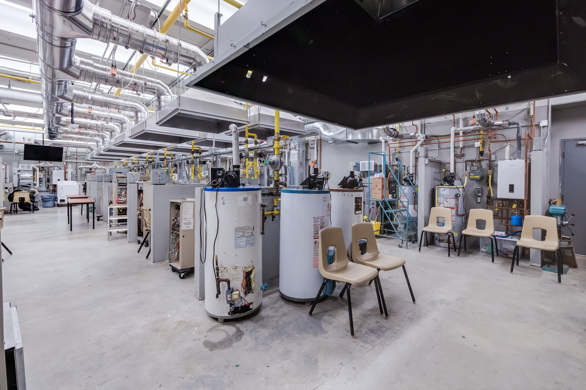 A large heating, ventilation, and air-conditioning classroom with rows of water heaters and gas appliances