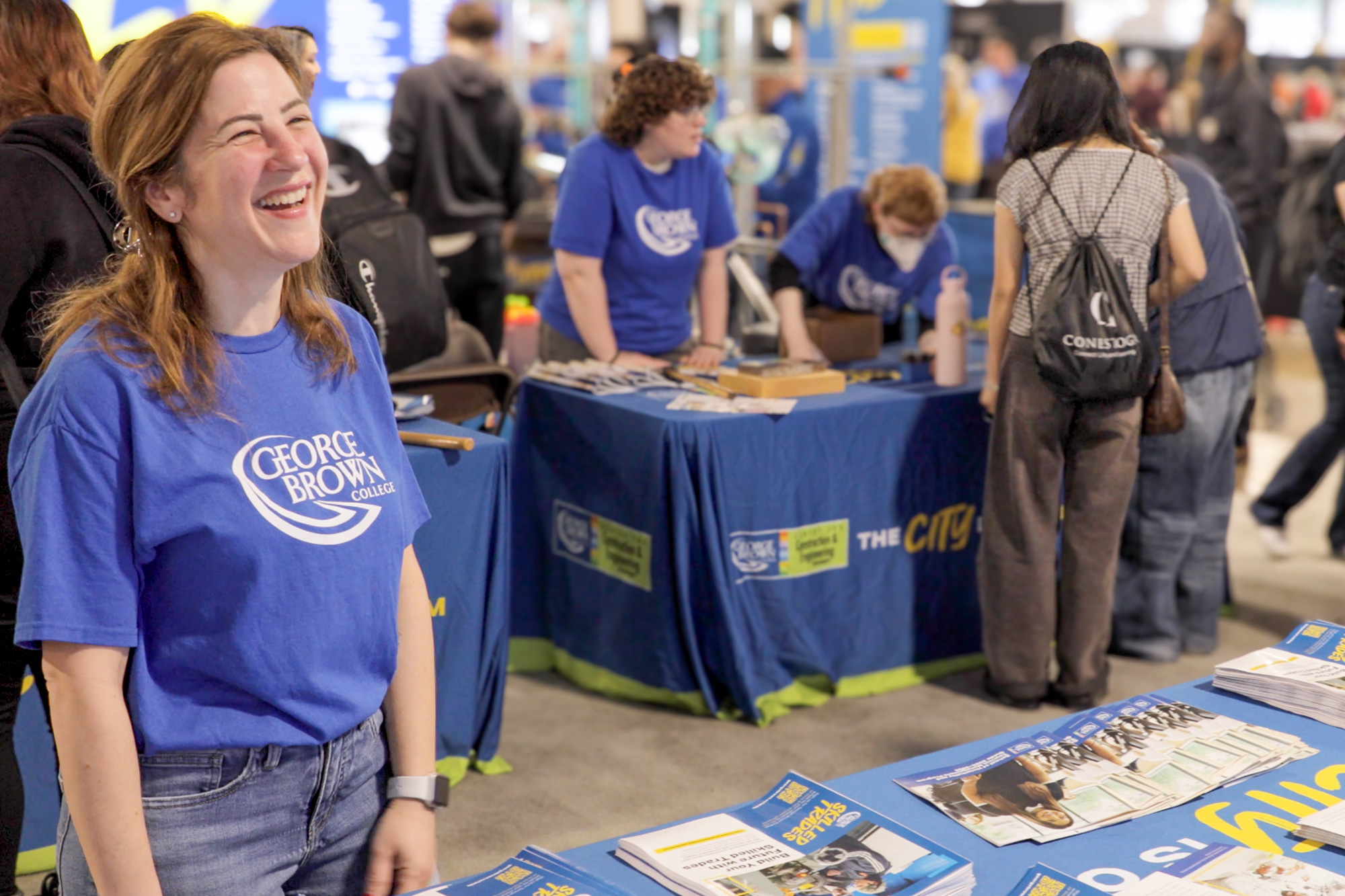 A woman in a blue GBC shirt smiles
