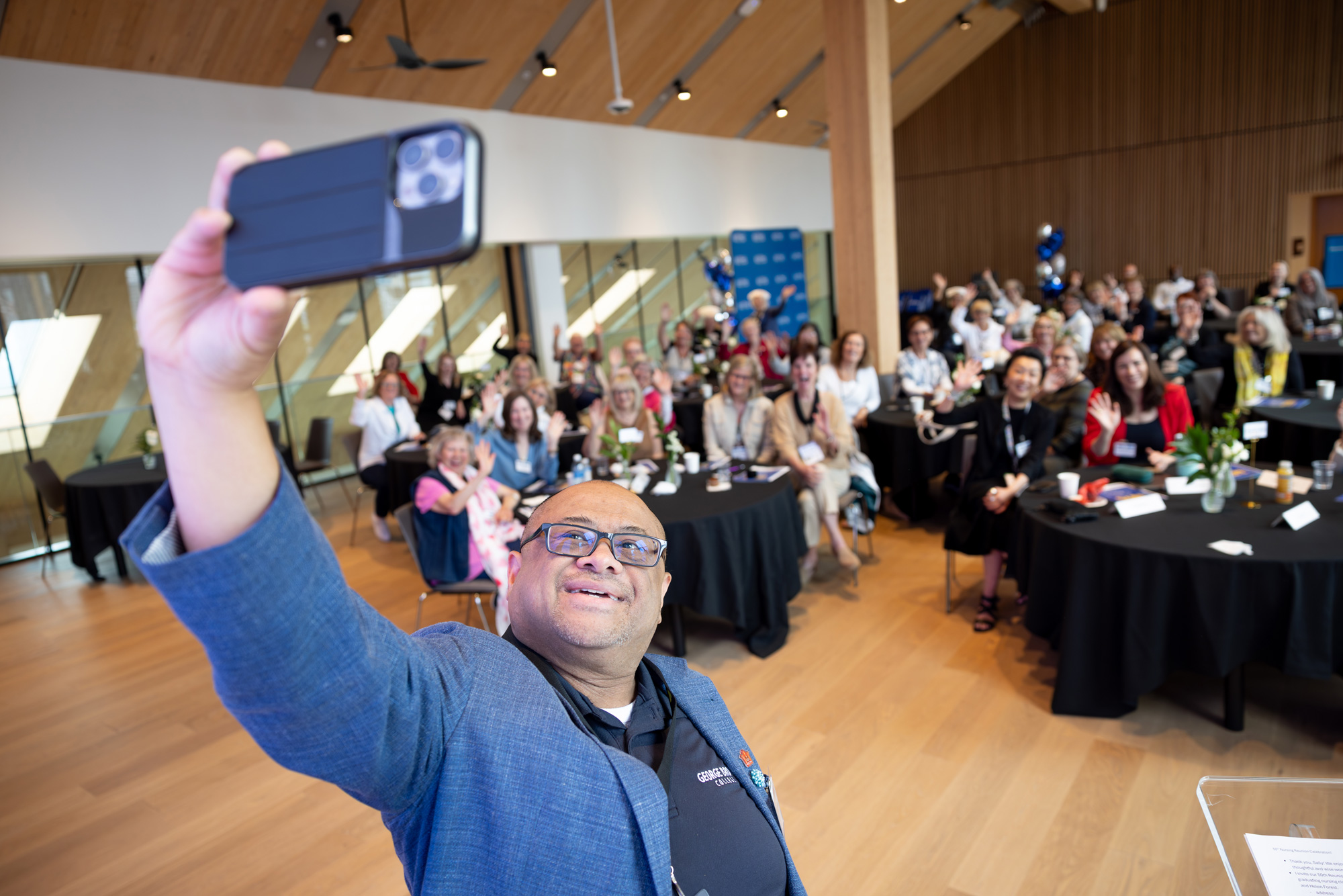 Michael Herrera, CFO at GBC, takes a selfie with graduating nursing class of 1975 at GBC's Limberlost Place