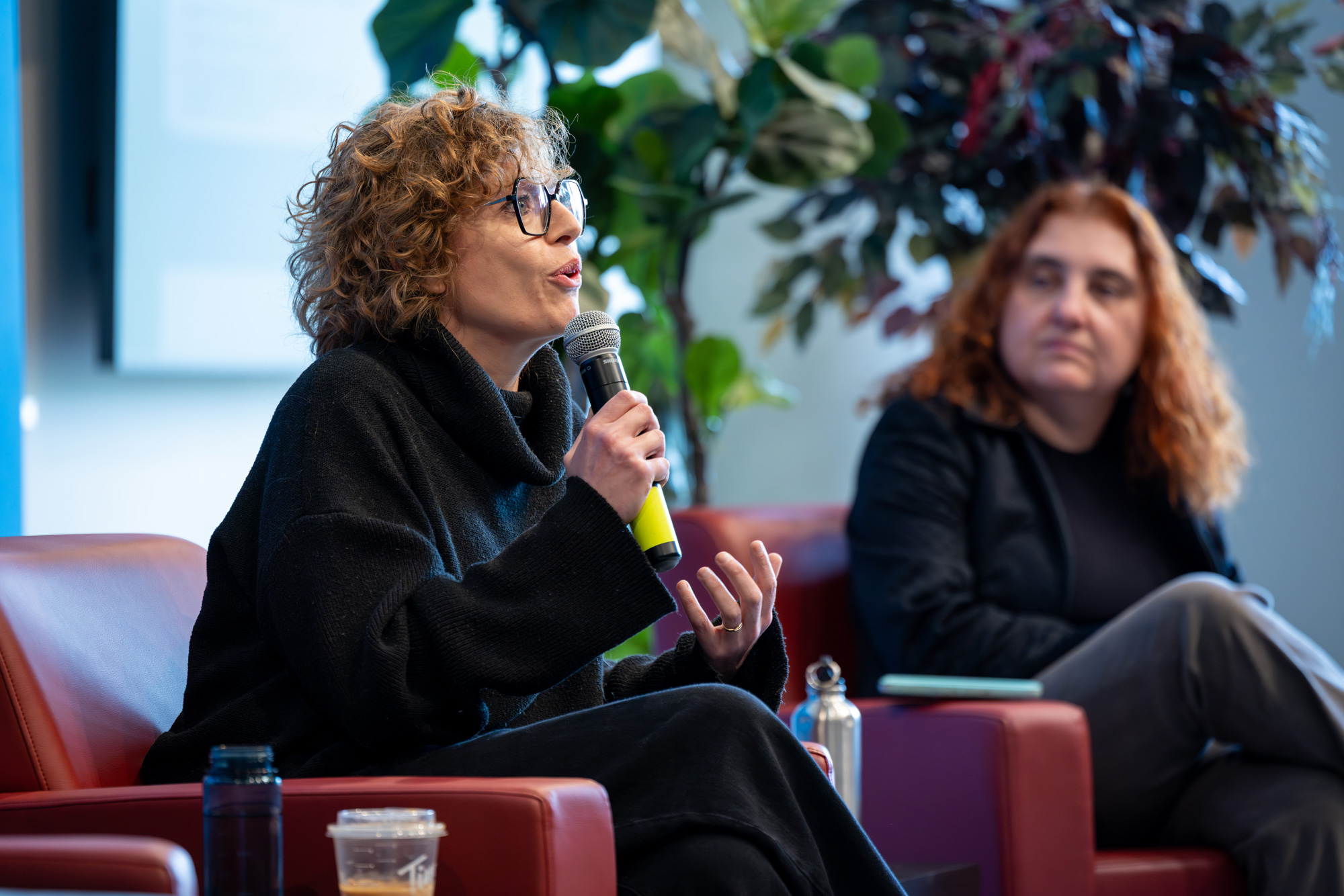 A panelist with a microphone speaks to the audience at the Pen Writer event