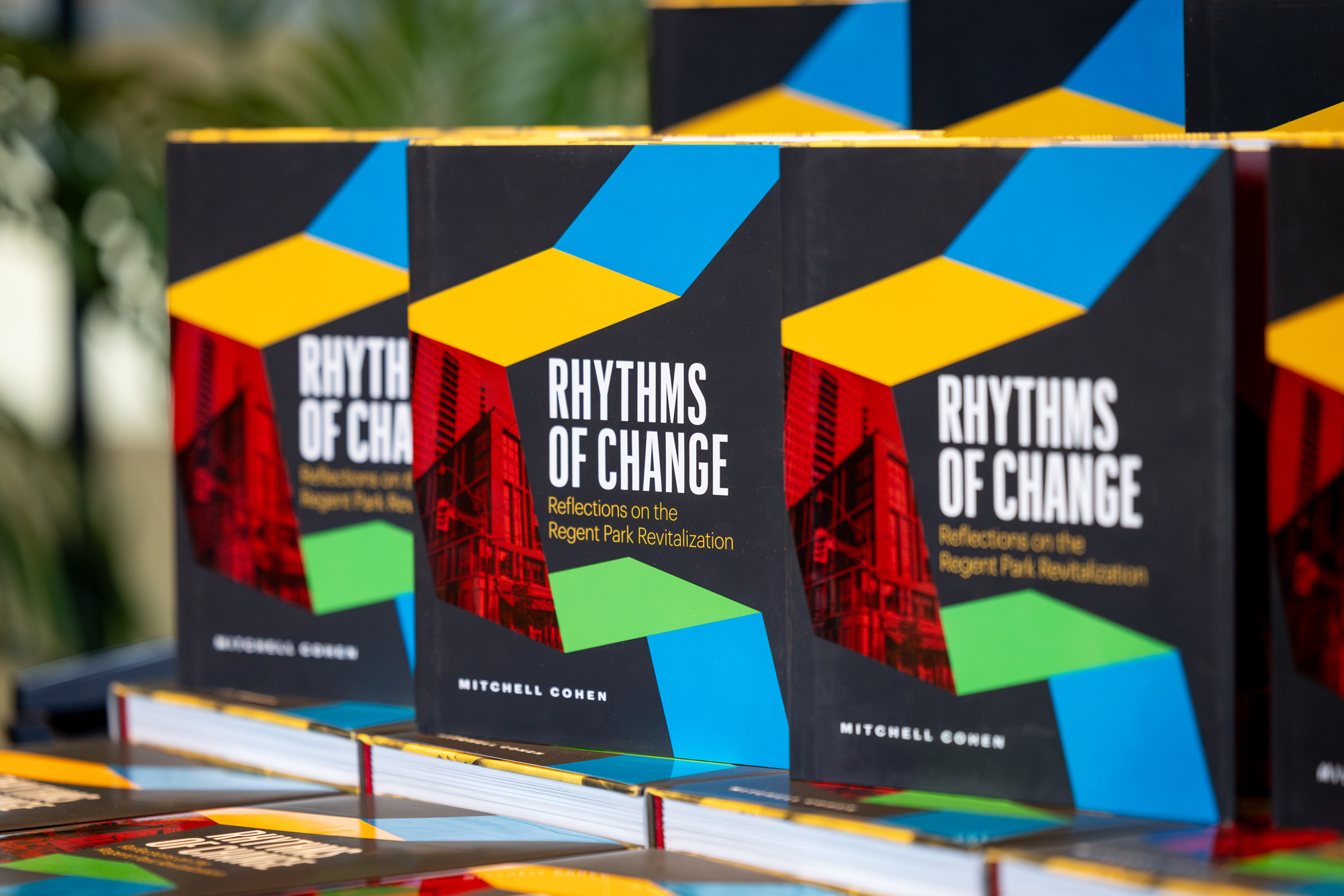Three copies of the book Rhythms of Change are stacked on a table