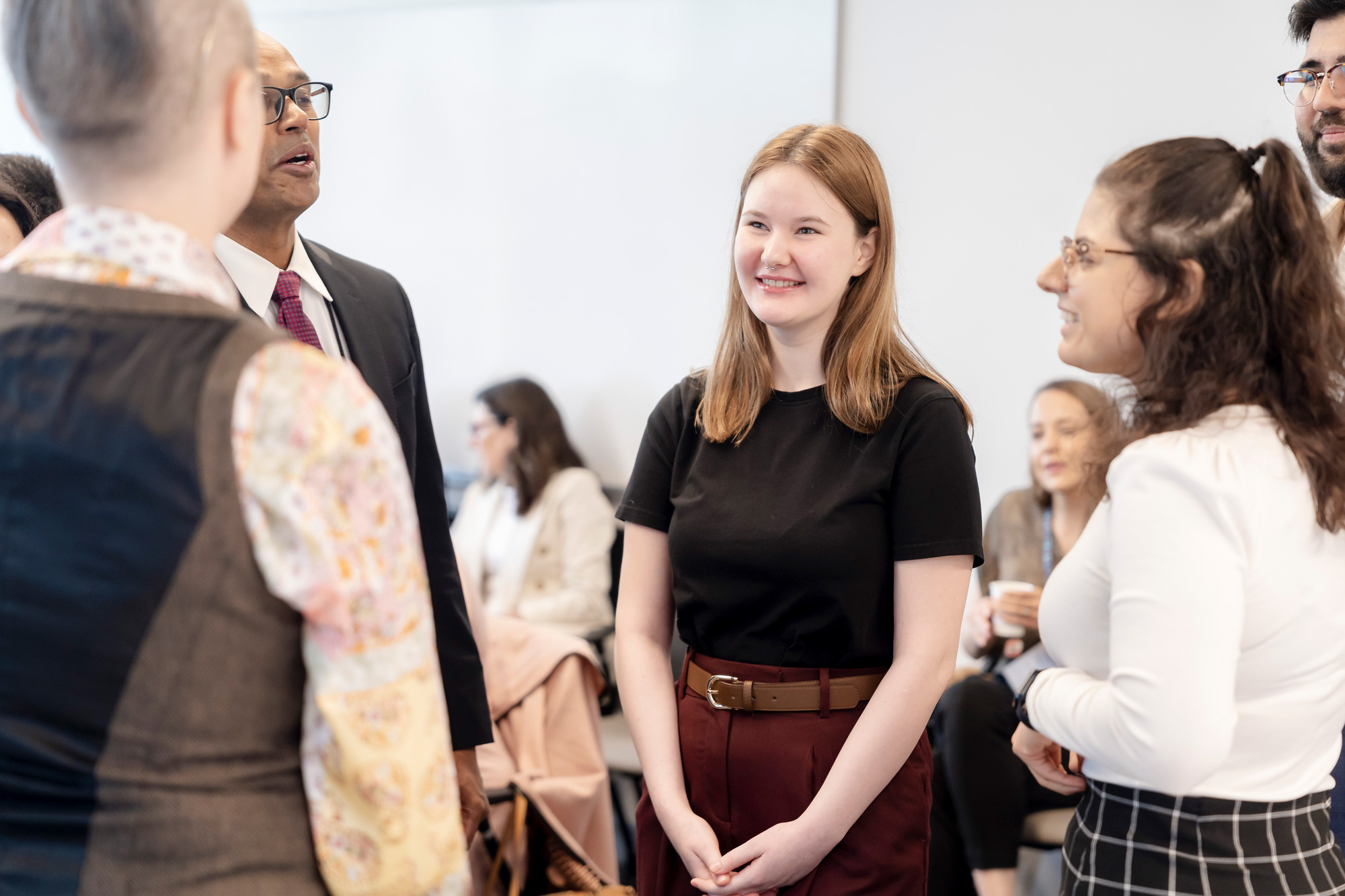 A women in a block top and red hair chats to guests in a Congress workshop