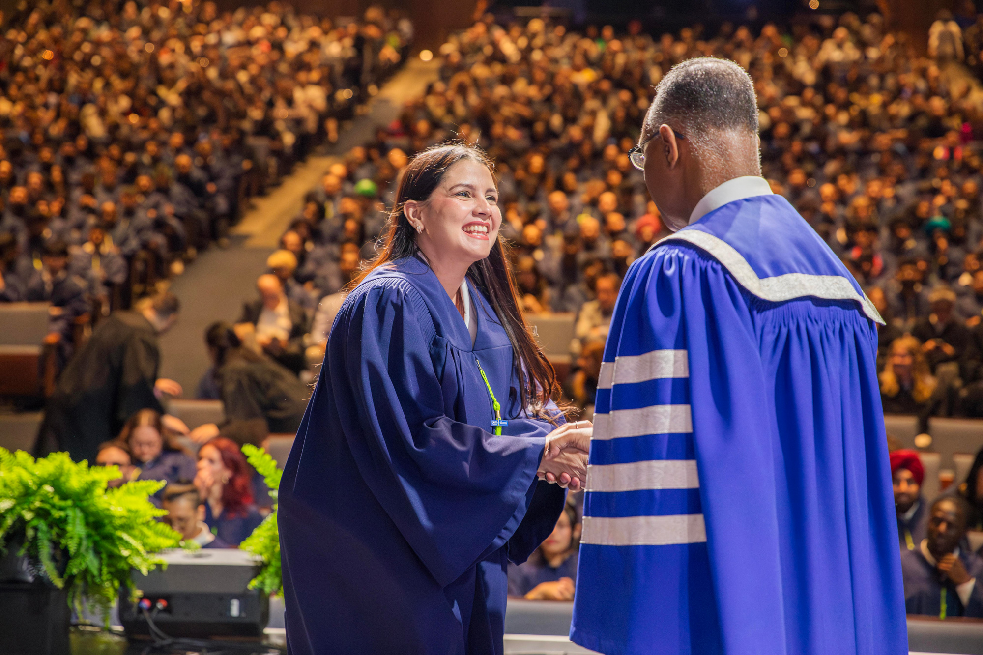 A GBC graduate on stage shakes President Fearon's hand