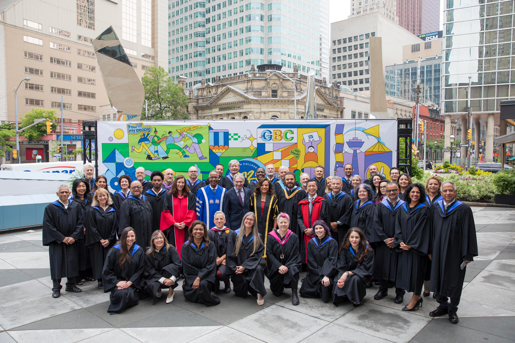 CCET faculty pose in front of a bright mural at convocation 2025