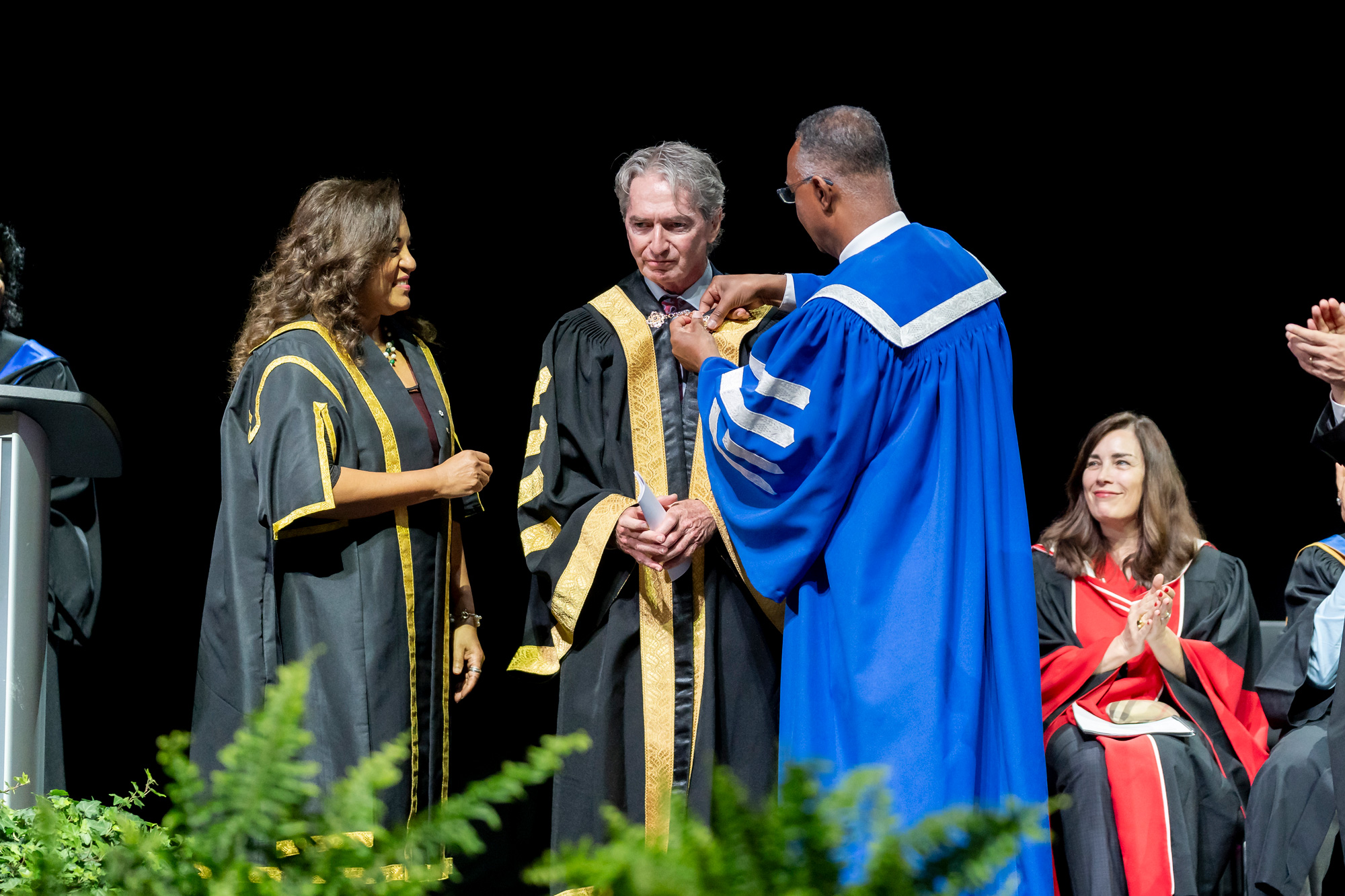 Chancellor Geoff Smith is installed as GBC's third chancellor on stage by President Fearon and Chancellor emeritus Noella Milne