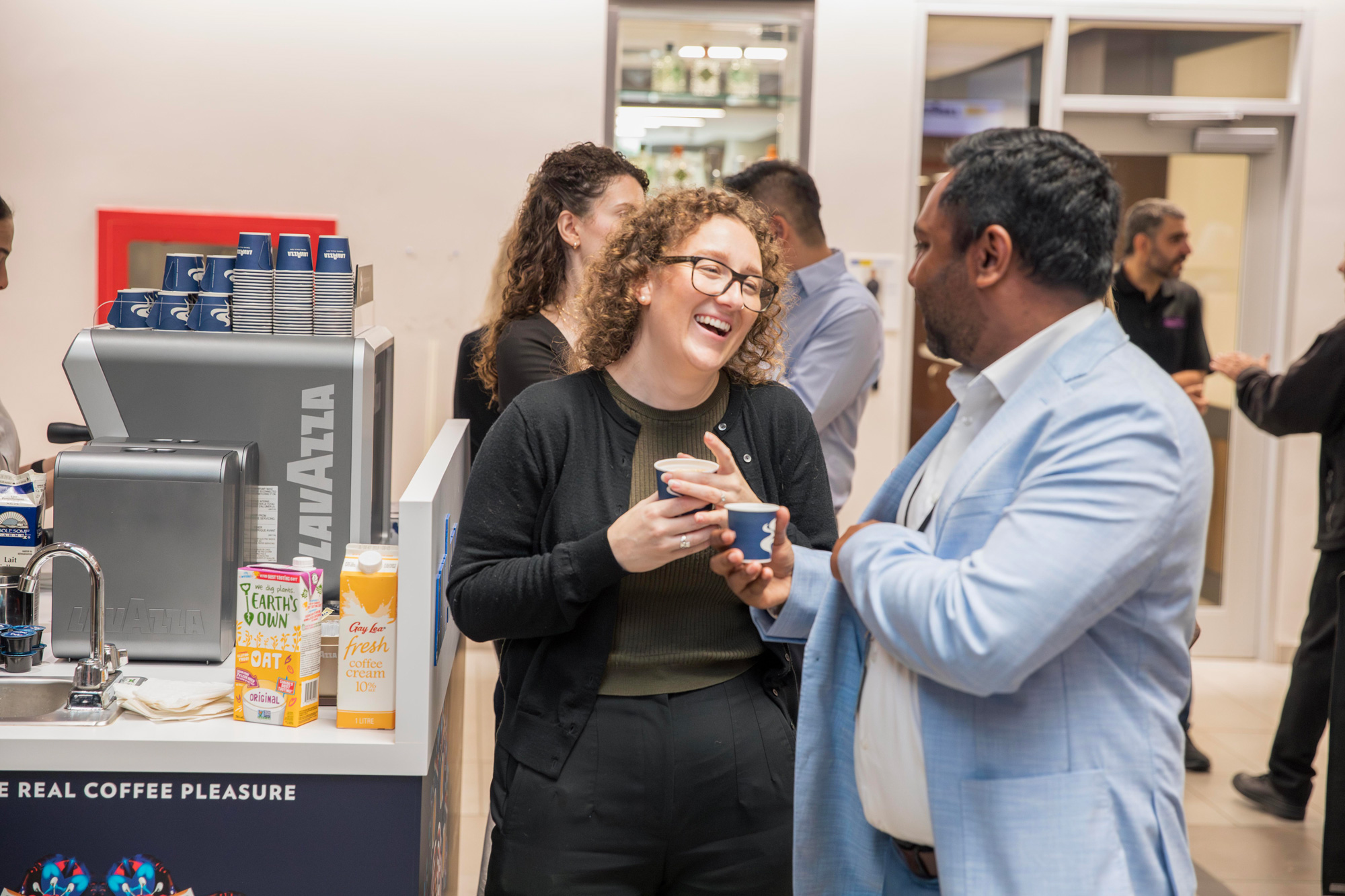 Two guests laugh together at the Lavazza partnership launch