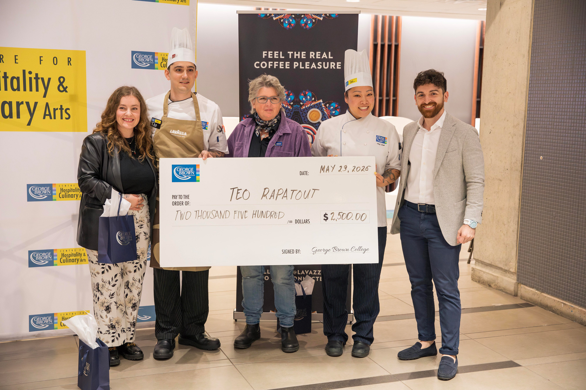Student winner, Teo Rapatout, poses with a large cheque and the Lavazza partners