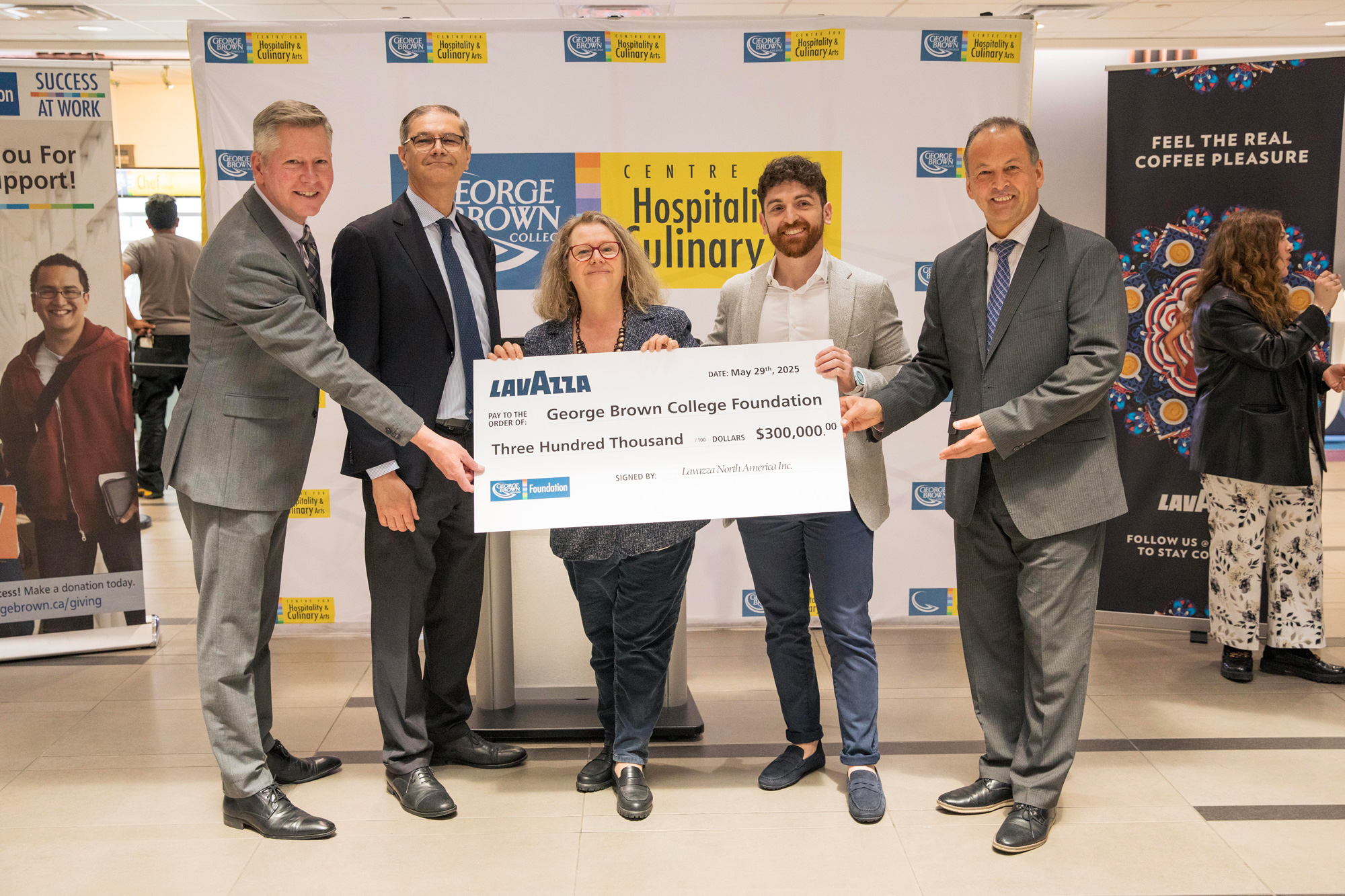 Members of George Brown and Lavazza pose with a large cheque to kick off the new partnership