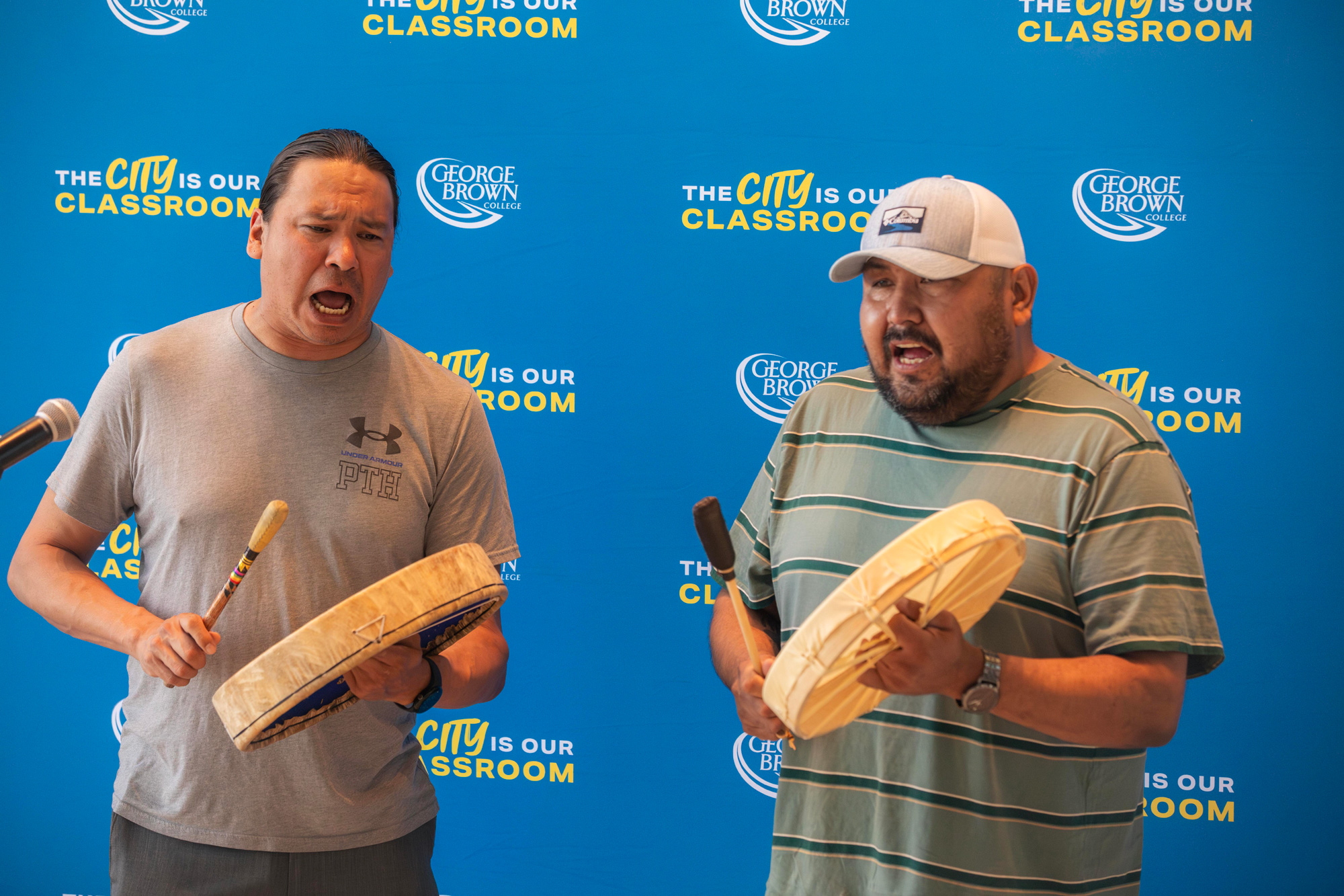 Two men drum and sing at the Mississauagas of the Credit First Nation exhibition
