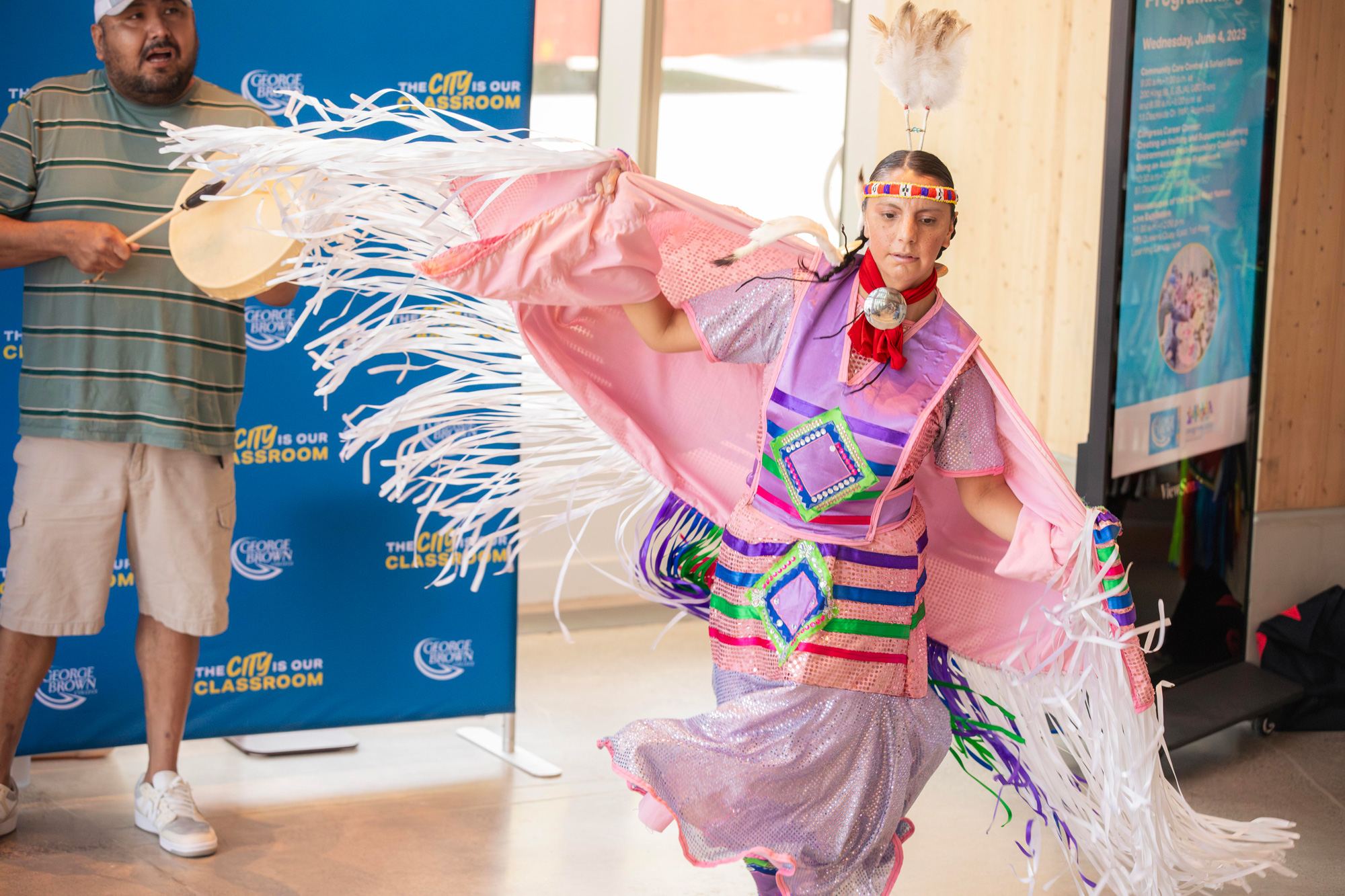 A women from the Mississaugas of the Credit First Nation dances in a pink traditional costume