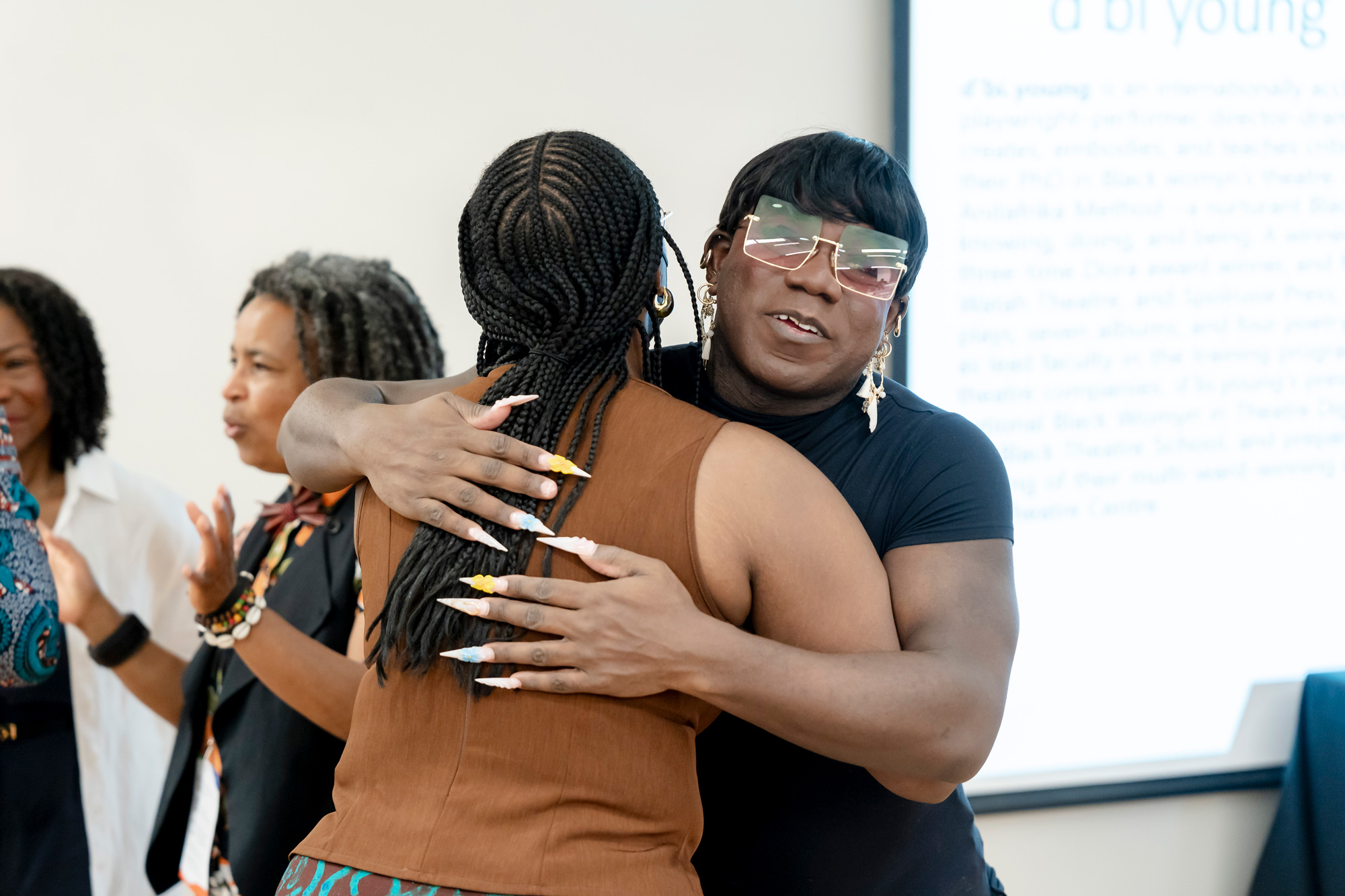 Panelist Ravyn Wngz embraces a guest in a hug