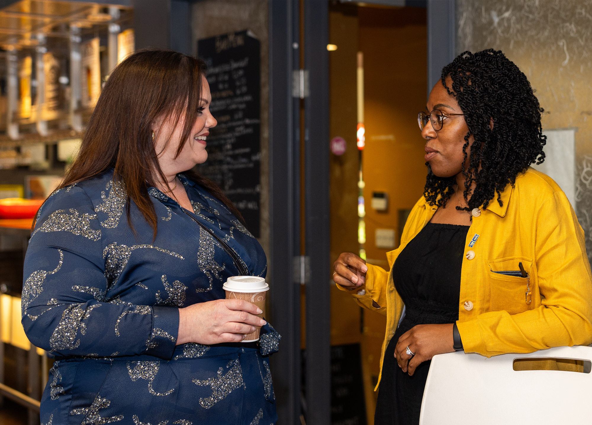 Two alumni chat at the summer social event