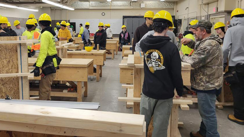 Students in hard hats train in carpentry lab, gaining hands-on skills for a career as a General Carpenter apprentice.