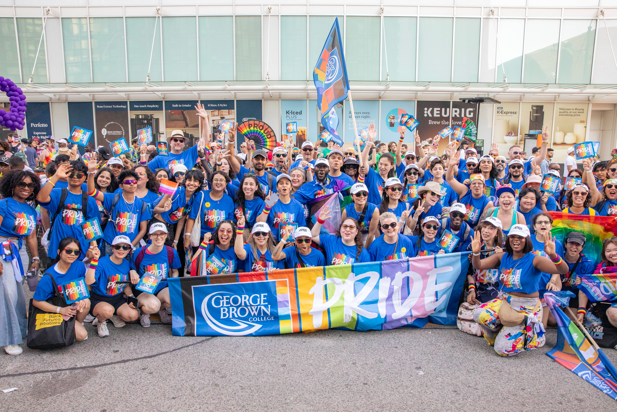 GBC students and staff pose as a group in bright blue Pride at GBC t-shirts