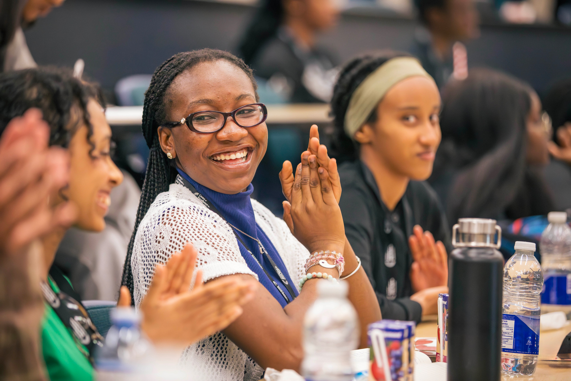 Seated students at the Black student summer leadership symposium smile and clap