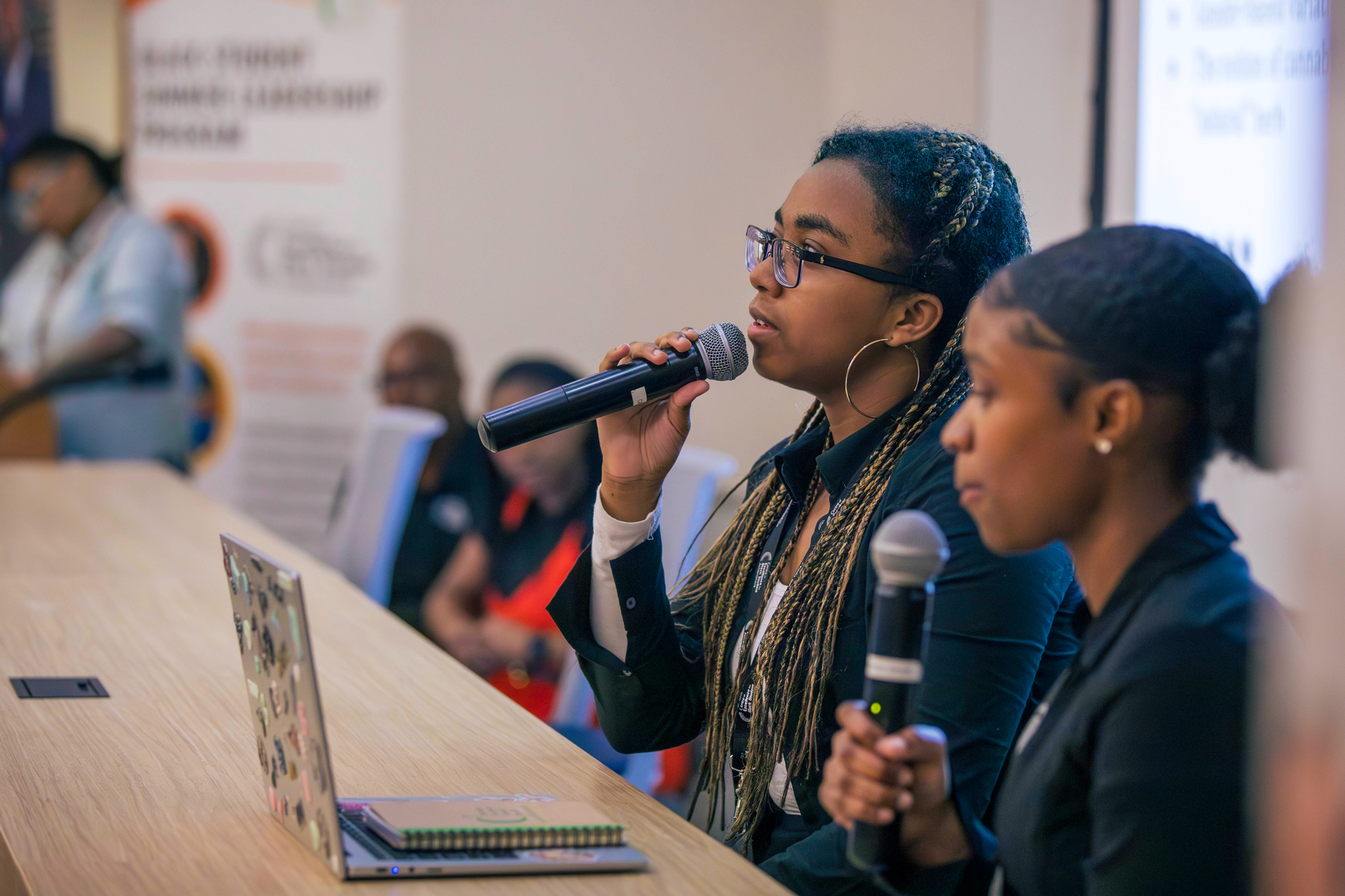 Student presenters speaks into a microphone at the Black student summer leadership symposium