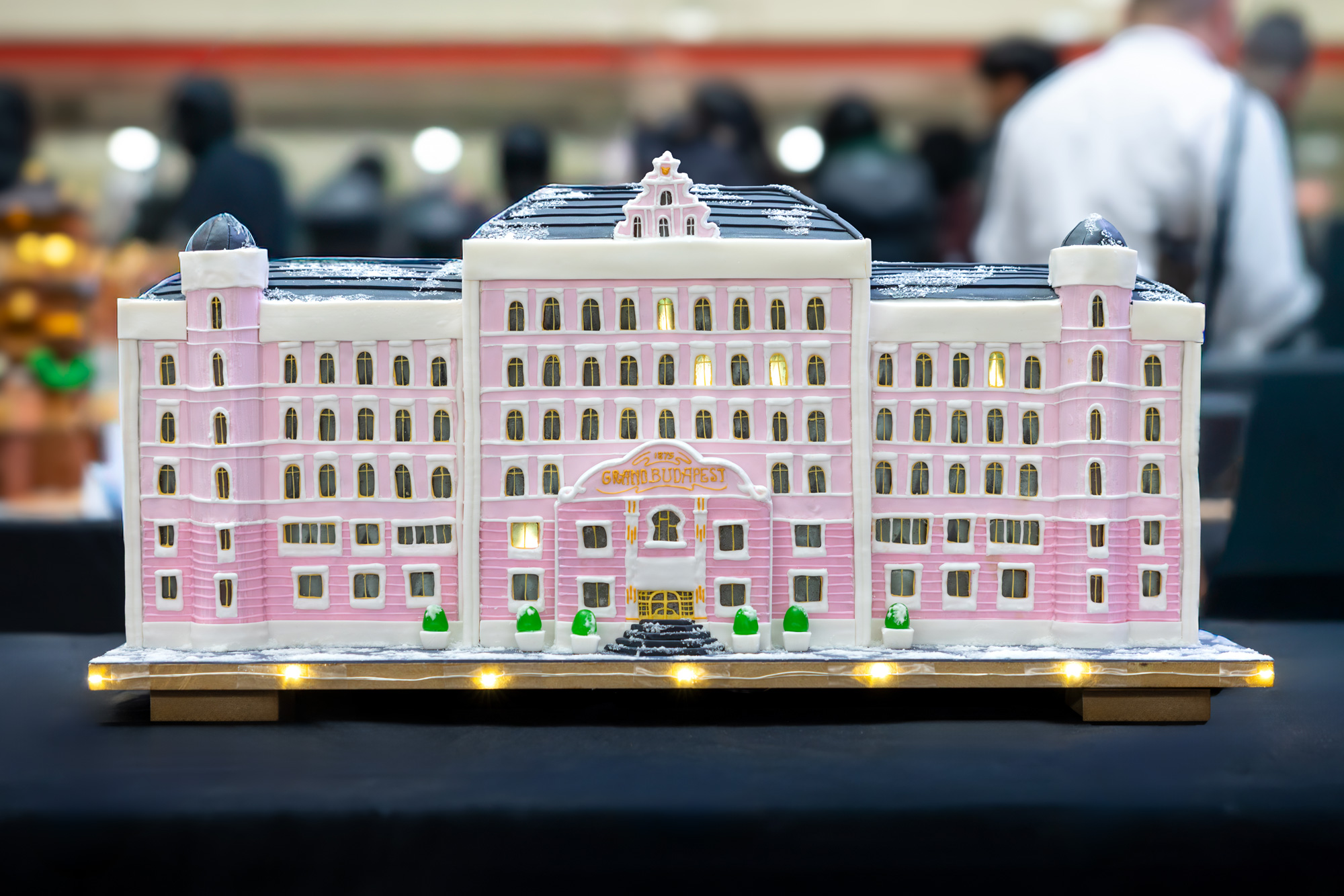 A gingerbread interpretation with pink walls and white icing depicts the facade of the Grand Budapest Hotel