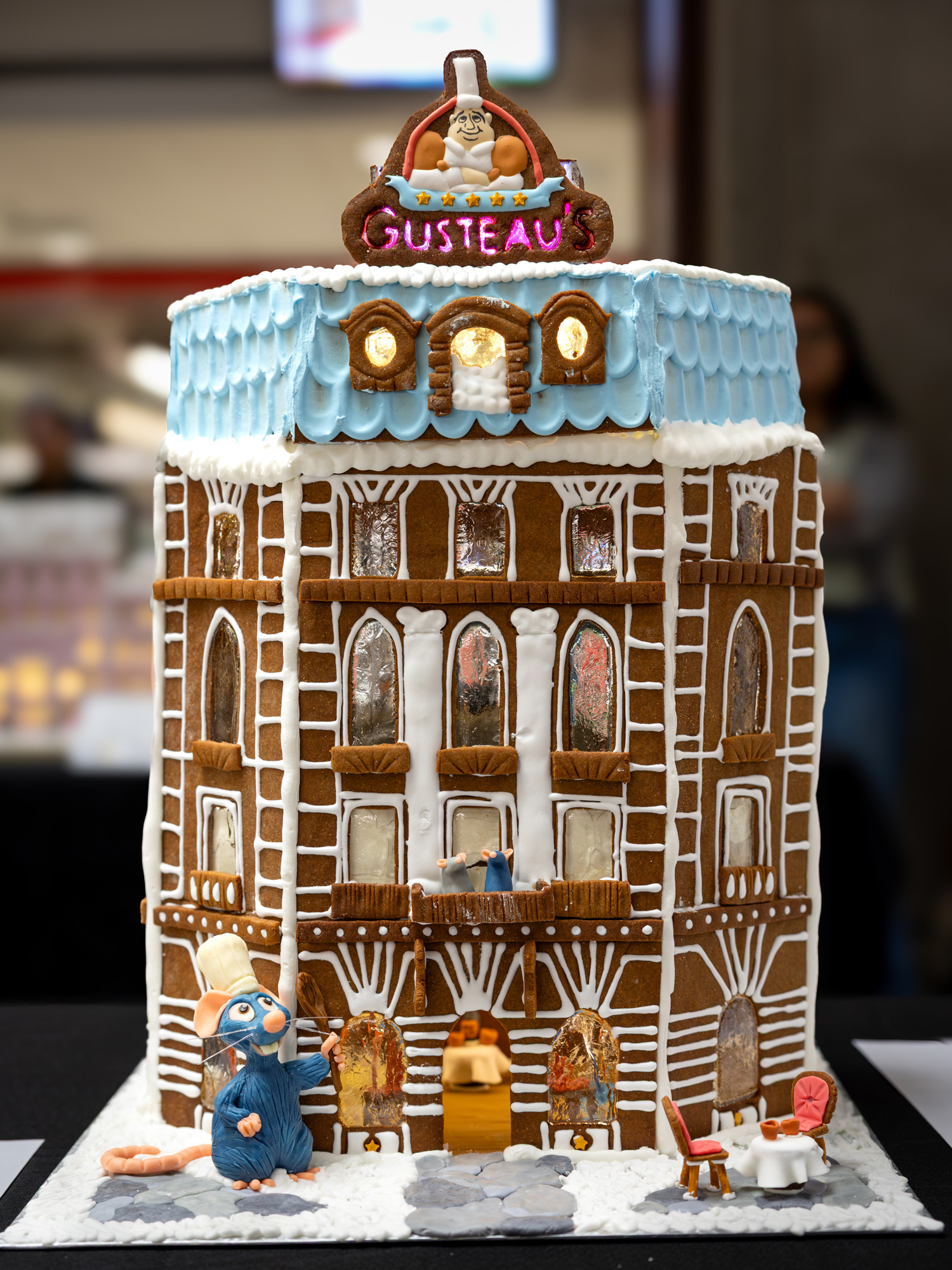 A multi-storey gingerbread building of Gusteau's from Ratatouille, compleete with mouse chef figure