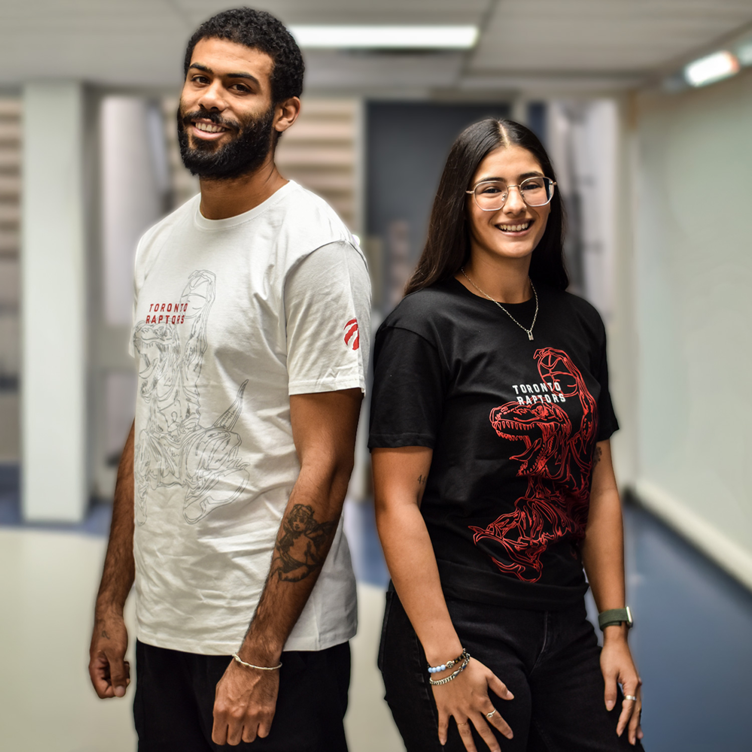 Two students pose in student designed Raptors shirts on campus