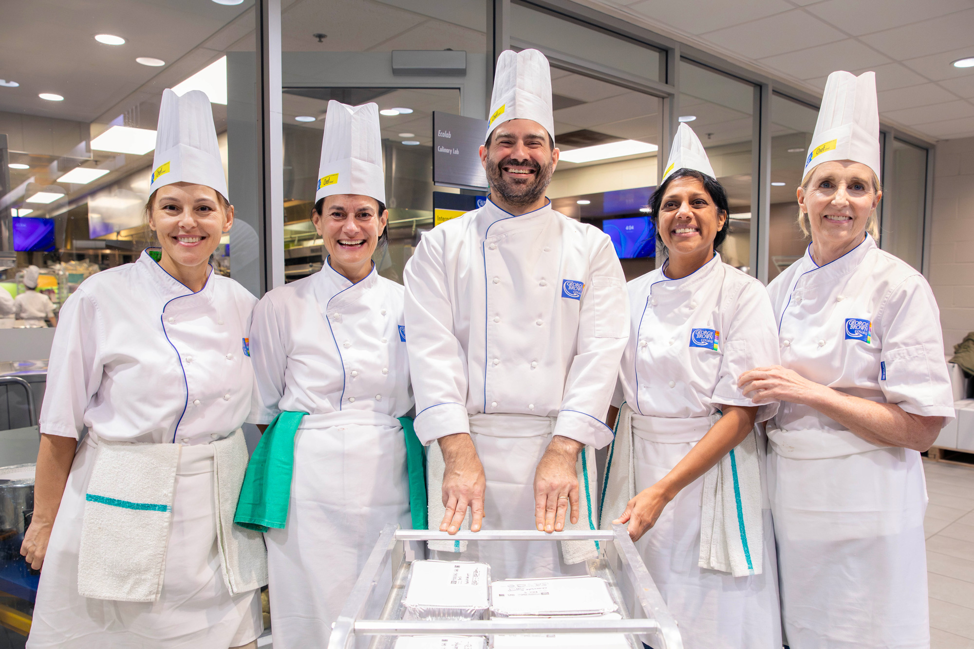 College leaders pose together in the Chef School kitchens as they prepare to deliver holiday meals