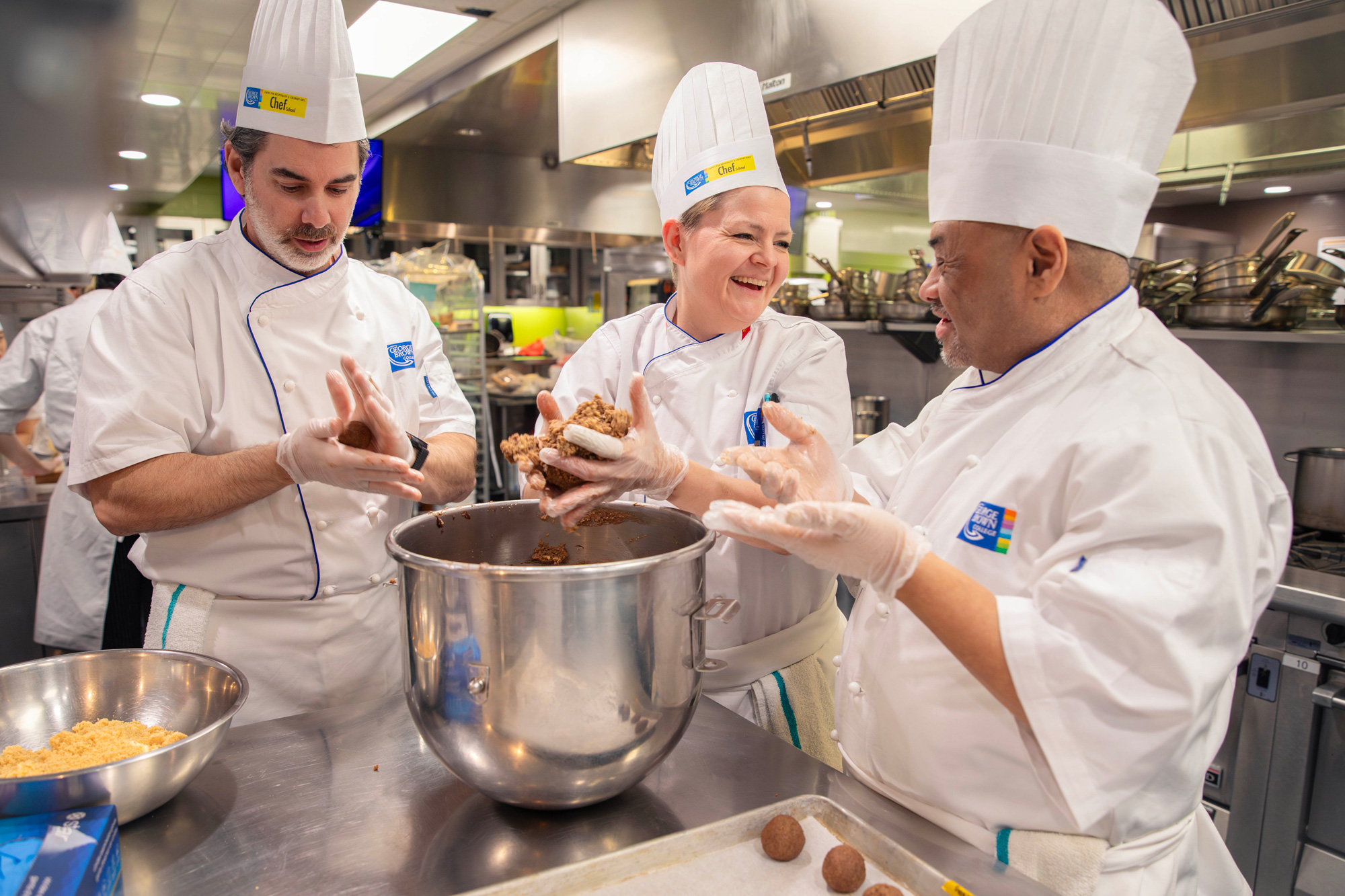 Senior leaders work with Chef School faculty to prepare holiday meals