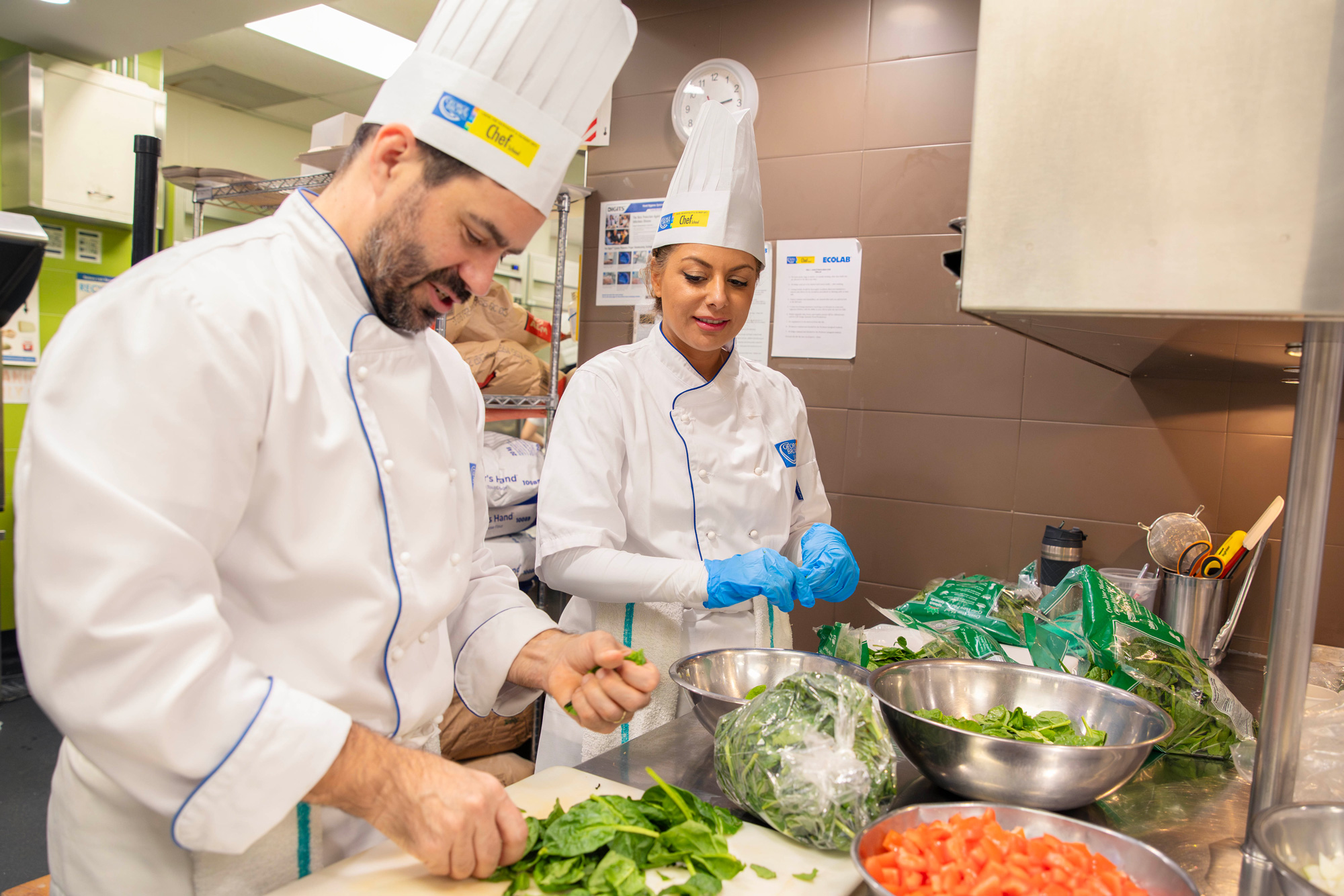 College leaders pose together in the Chef School kitchens as they prepare holiday meals