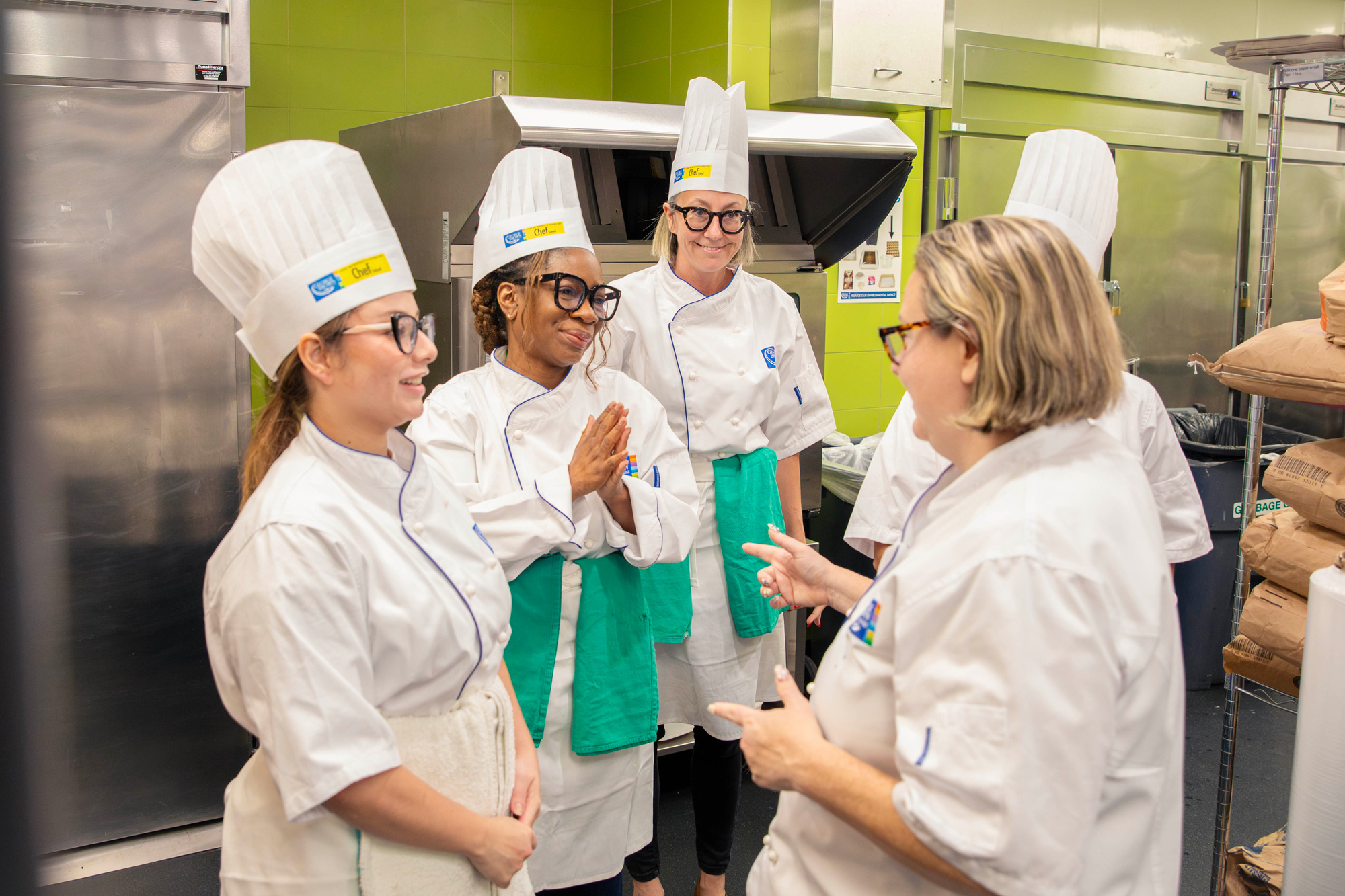 College leaders pose together in the Chef School kitchens as they prepare holiday meals