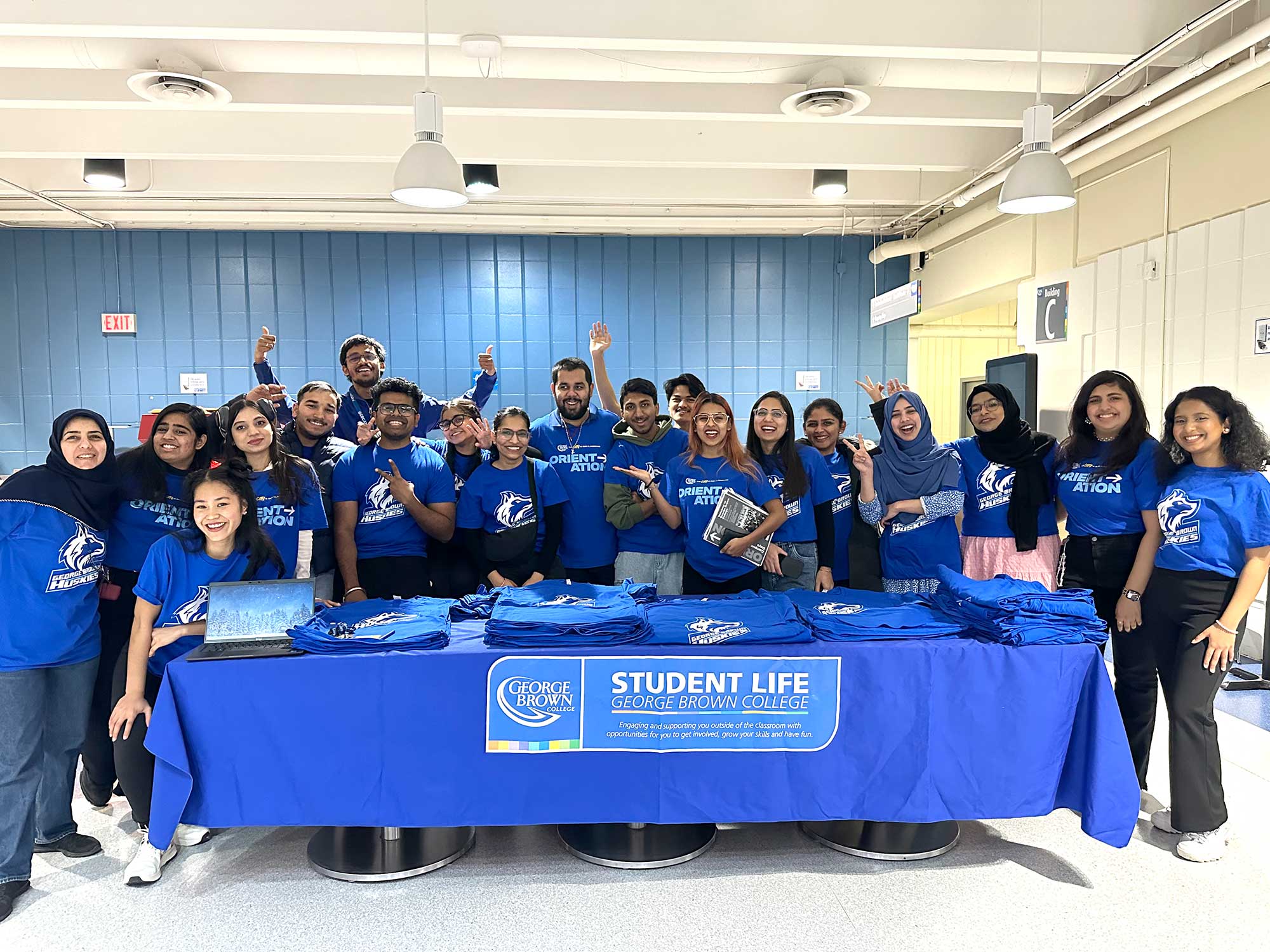 Student volunteers stand around a desk to pose for the camera.