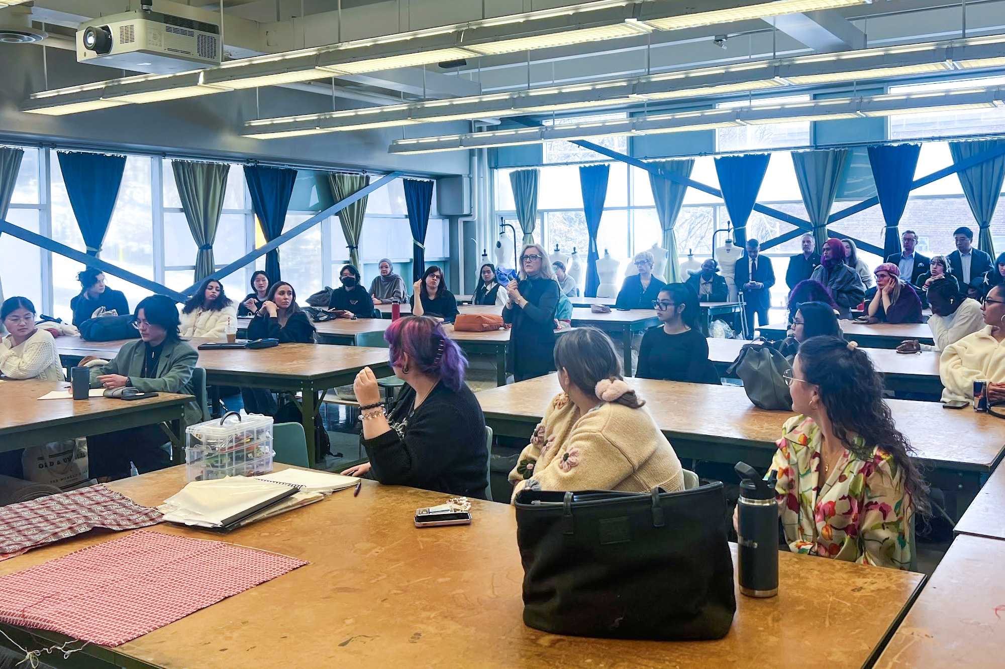 Professor Cynthia Givens-Sanford talks to fashion student participants in a classroom