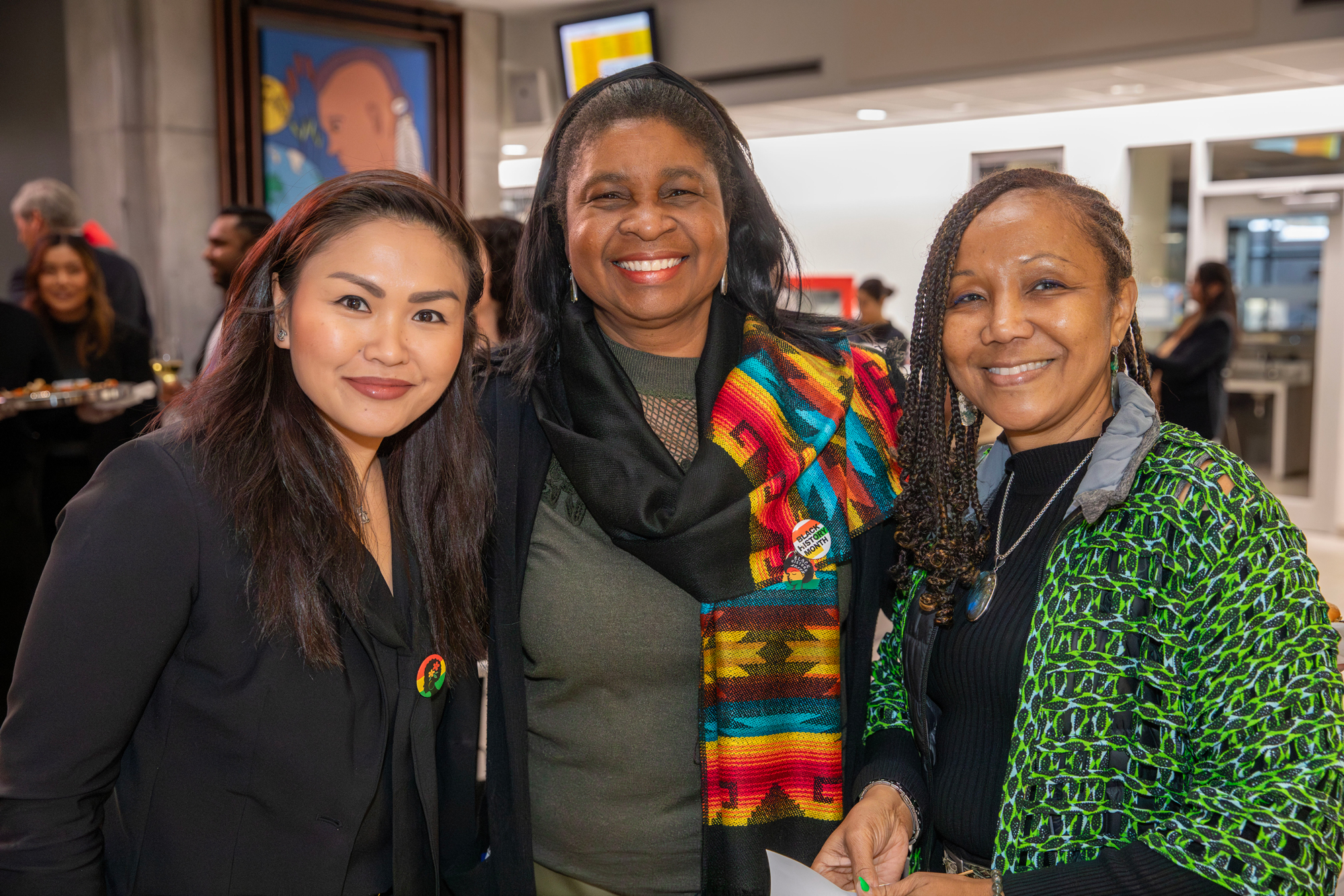 Three women pose together smiling at the Hubbard Atrium naming event