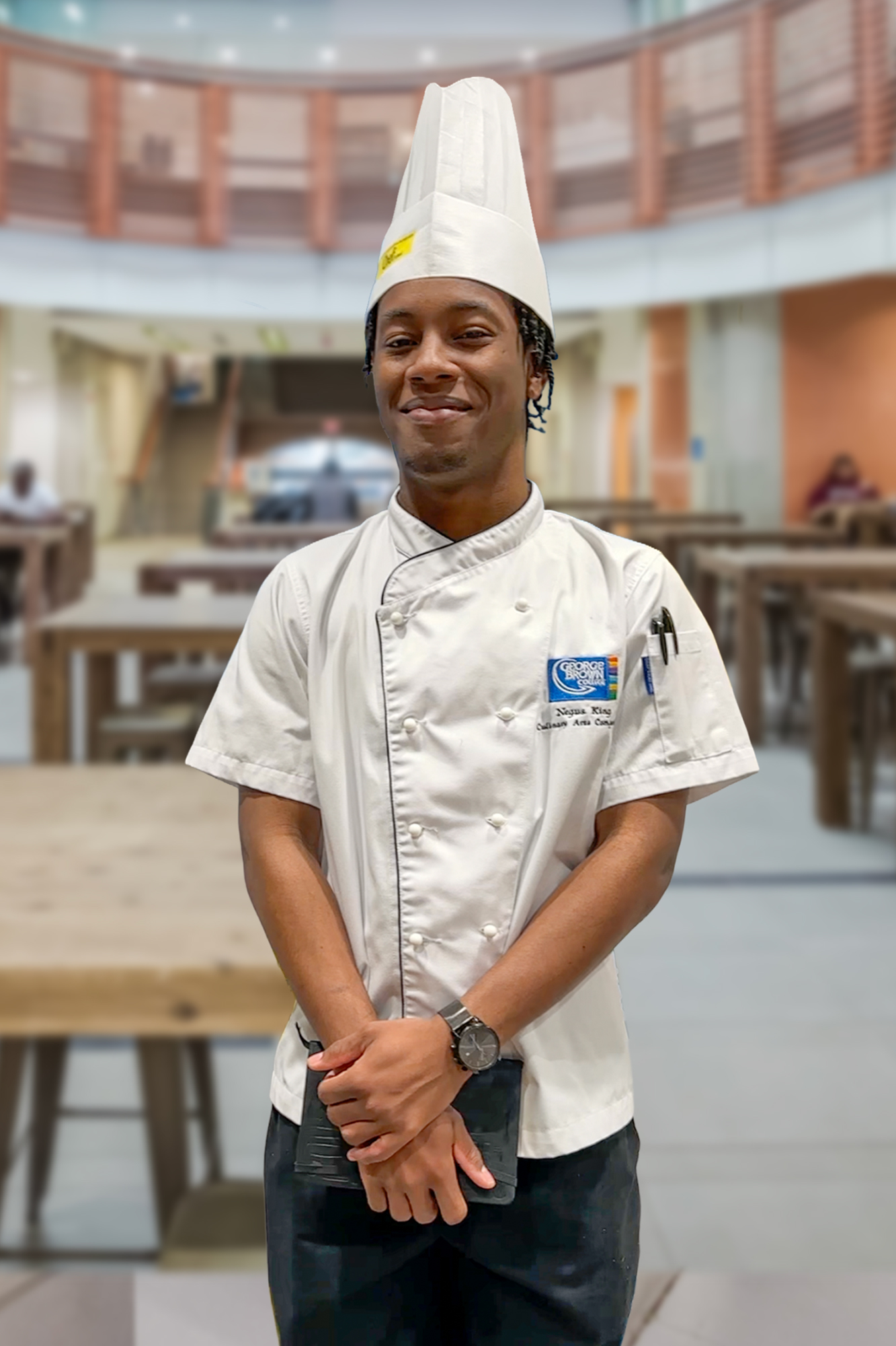 Negus King stands in the Chef School atrium in his chef whites