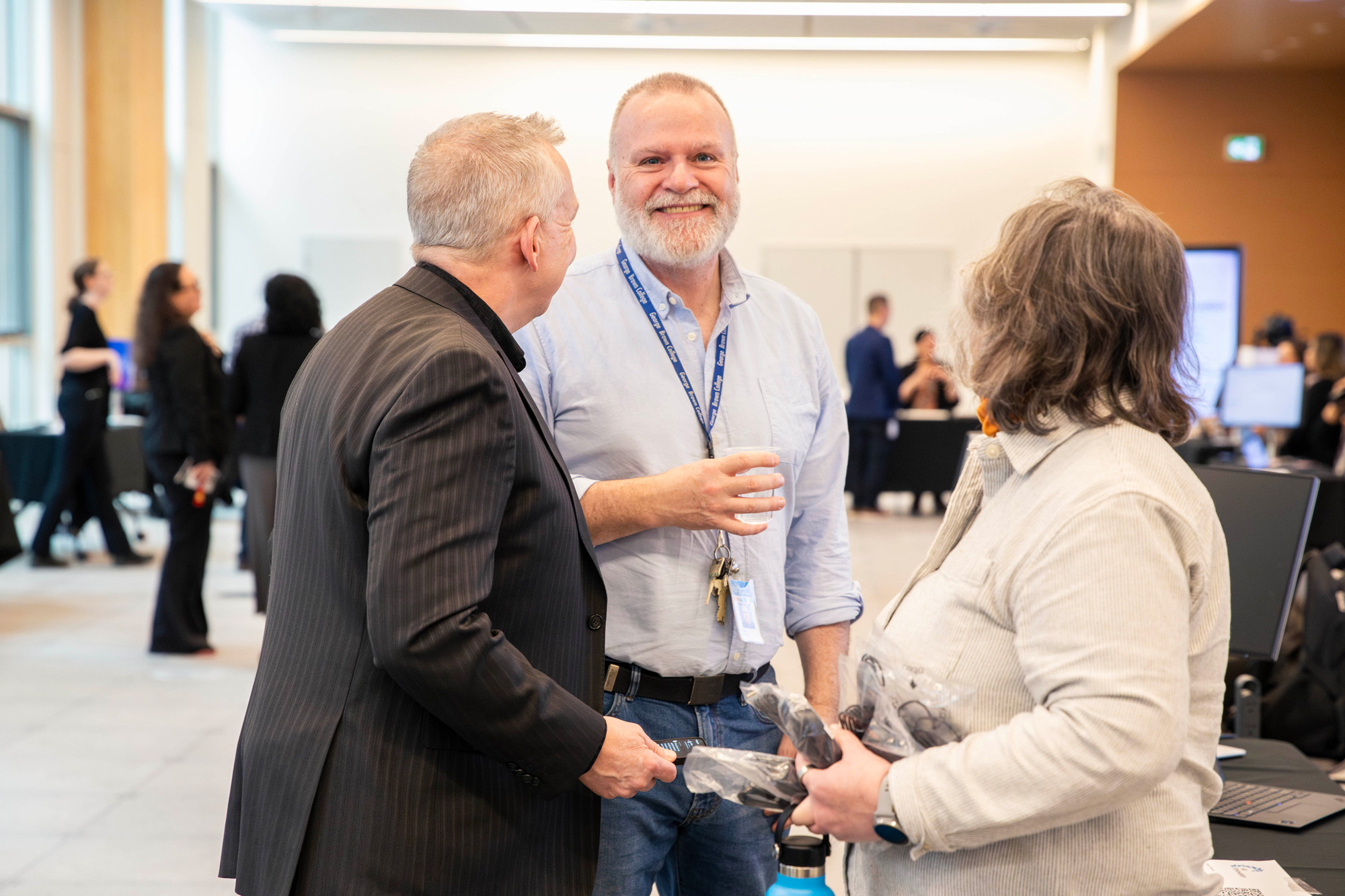 Staff chat share ideas at the AI Innovation Showcase