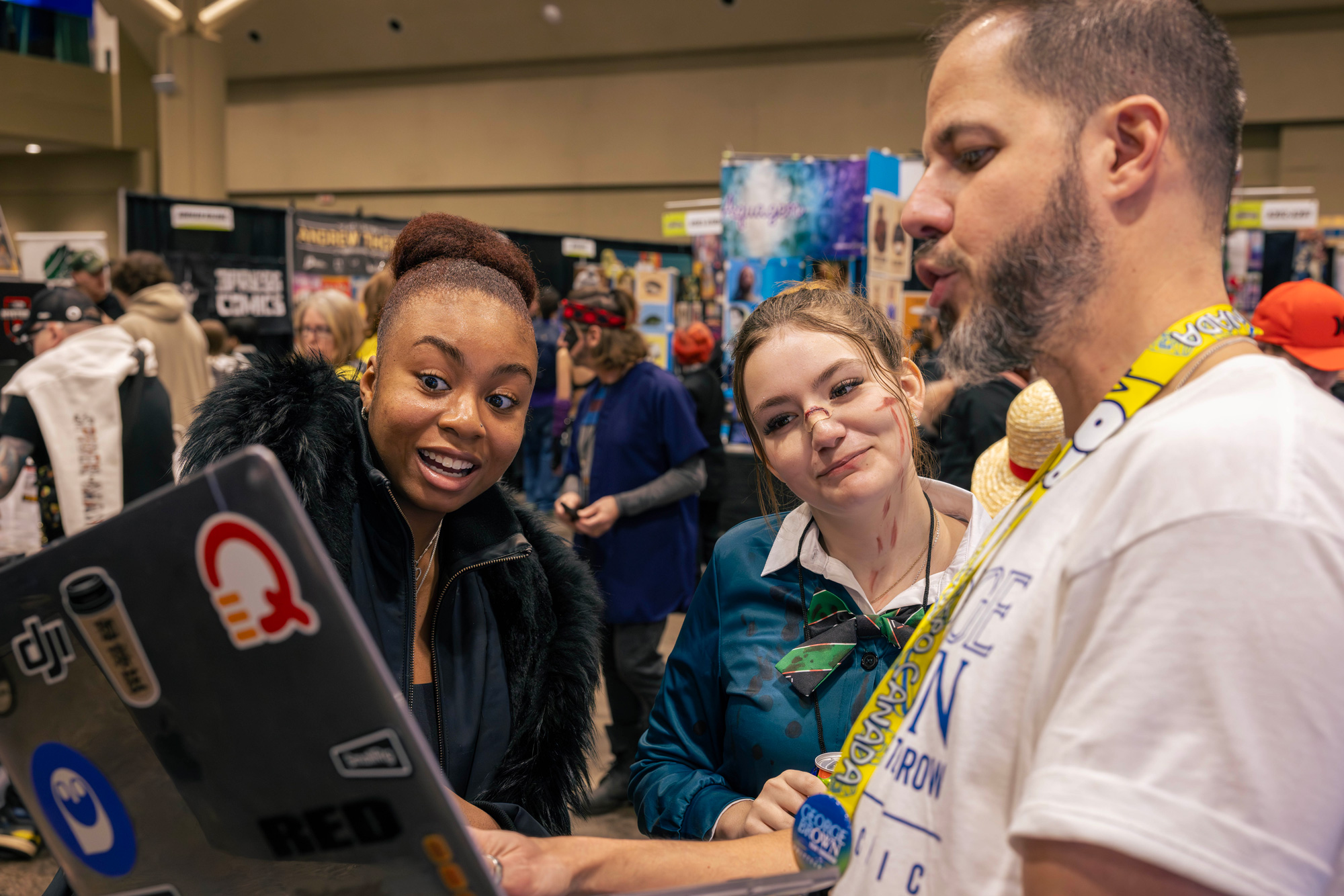 Guests speak with staff at Comicon about programs at George Brown