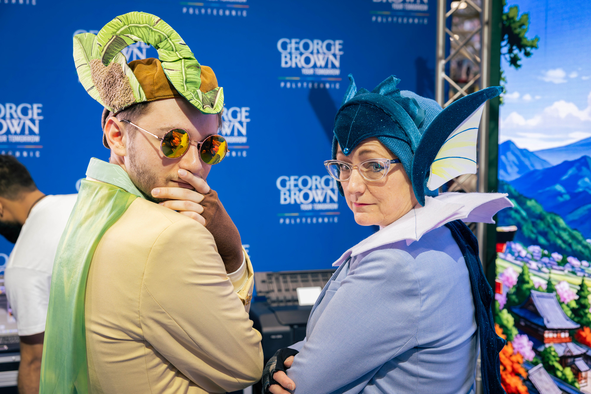Two guests in cosplay pose at the George Brown booth at Comicon
