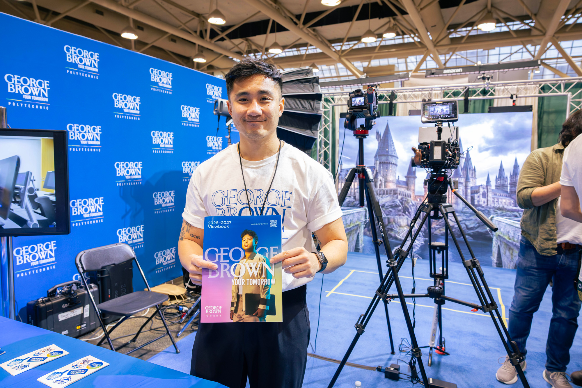 Staff pose with a viewbook at the George Brown Comicon booth