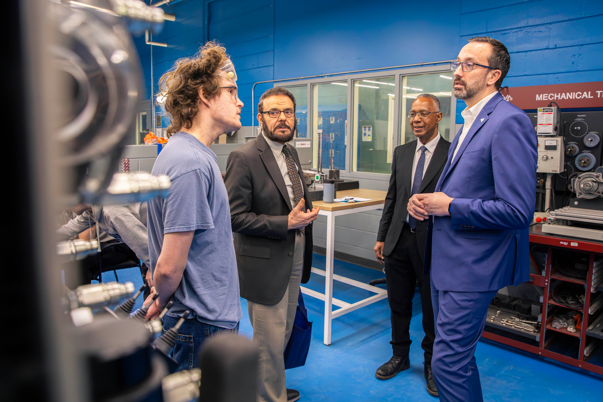 Minister Quinn talks to a student in the millwright lab