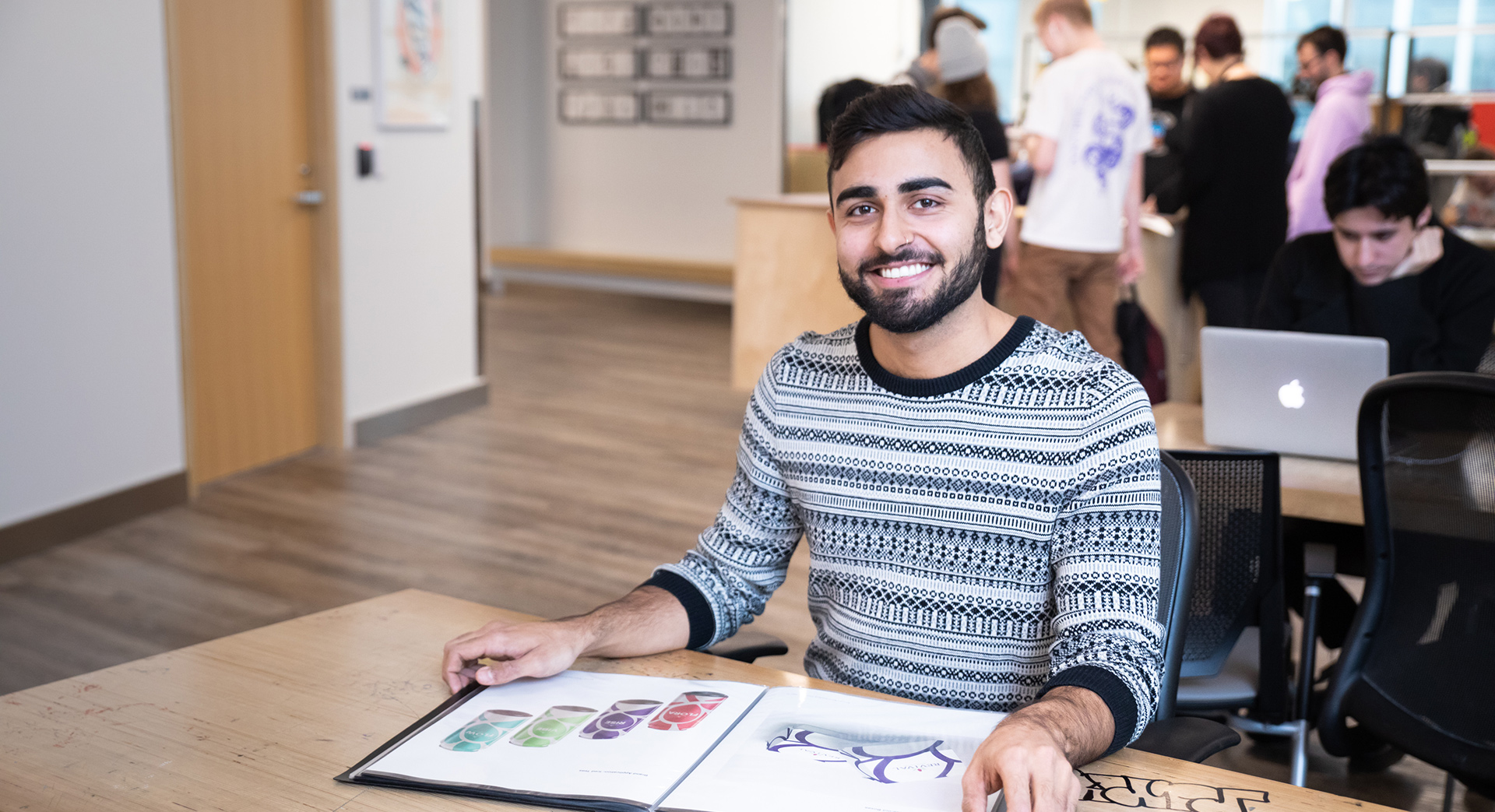 design student sitting in a classroom with an open sketchbook