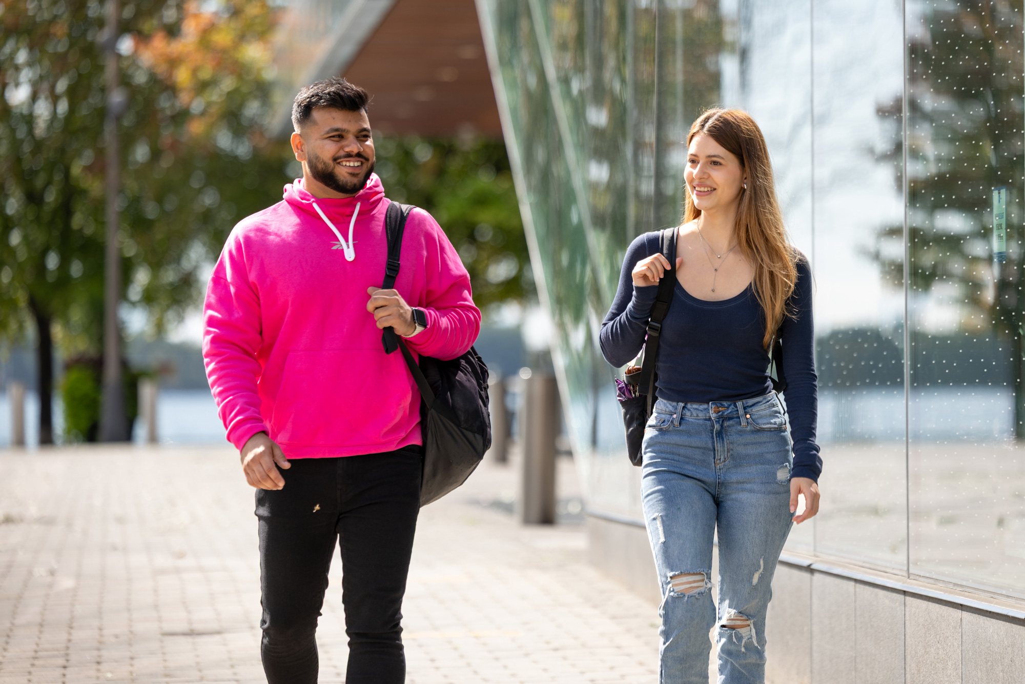Two students walking outside of Waterfront campus on a sunny day